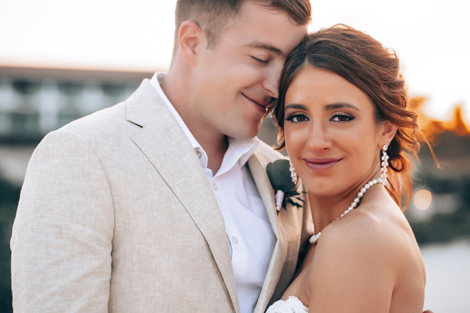 Romantic sunset wedding portraits captured against coastal backdrop.