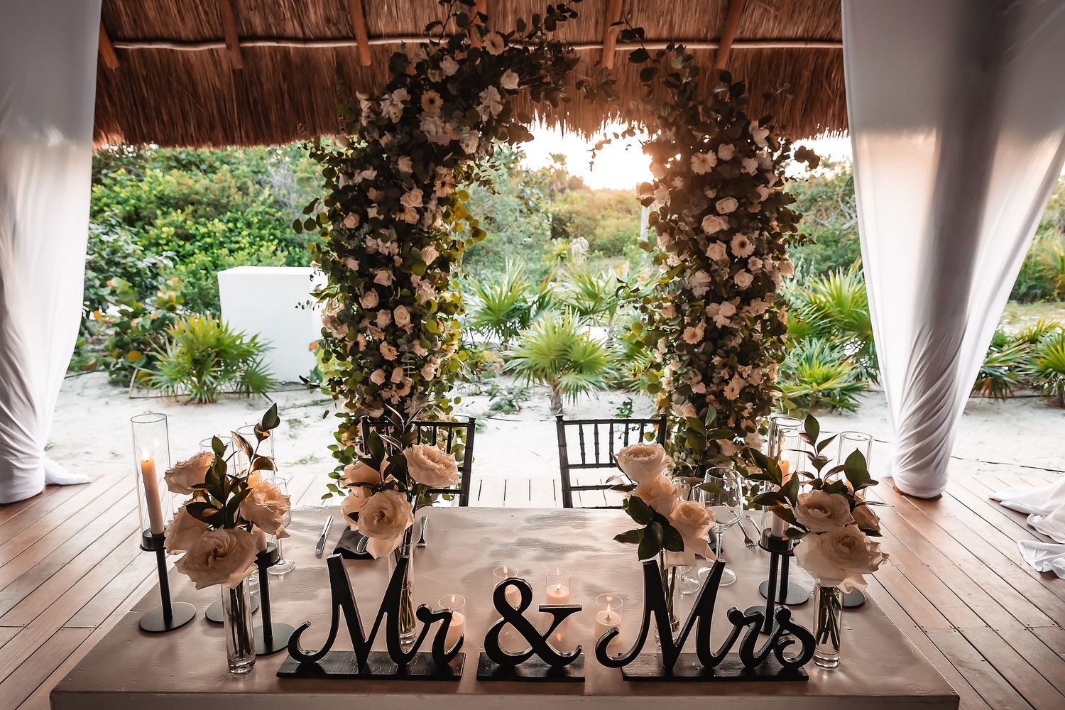 Wedding reception venue with rustic wooden ceiling beams and elegant floral decorations.