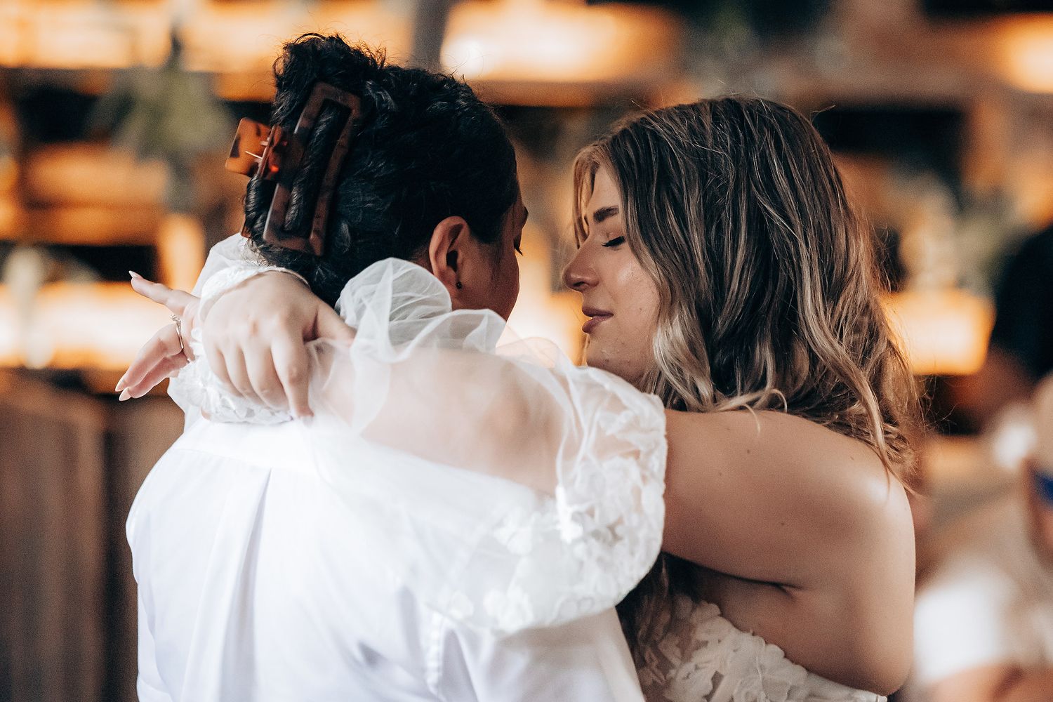 A romantic couple shares tender kisses in a series of intimate wedding photos with warm lighting and elegant attire.