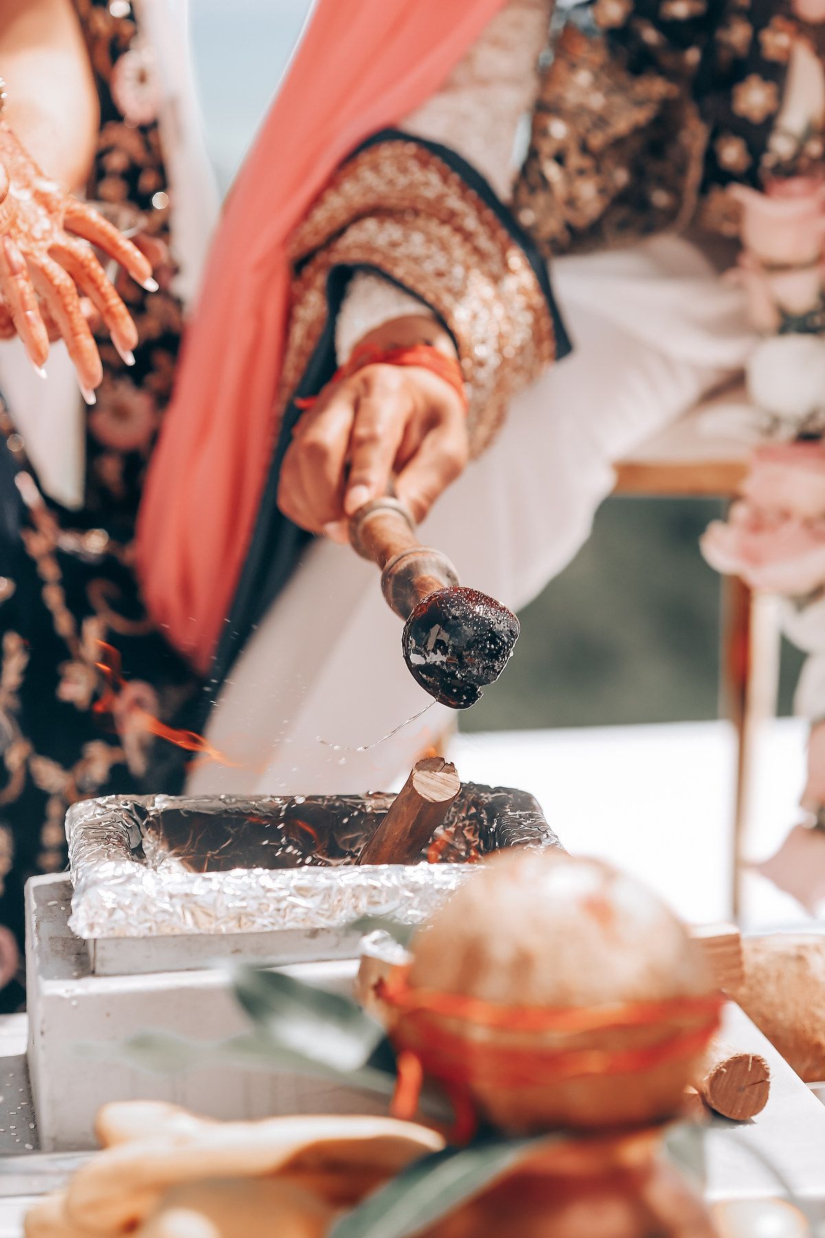 Close-up shot of hands preparing traditional food during an outdoor celebration.
