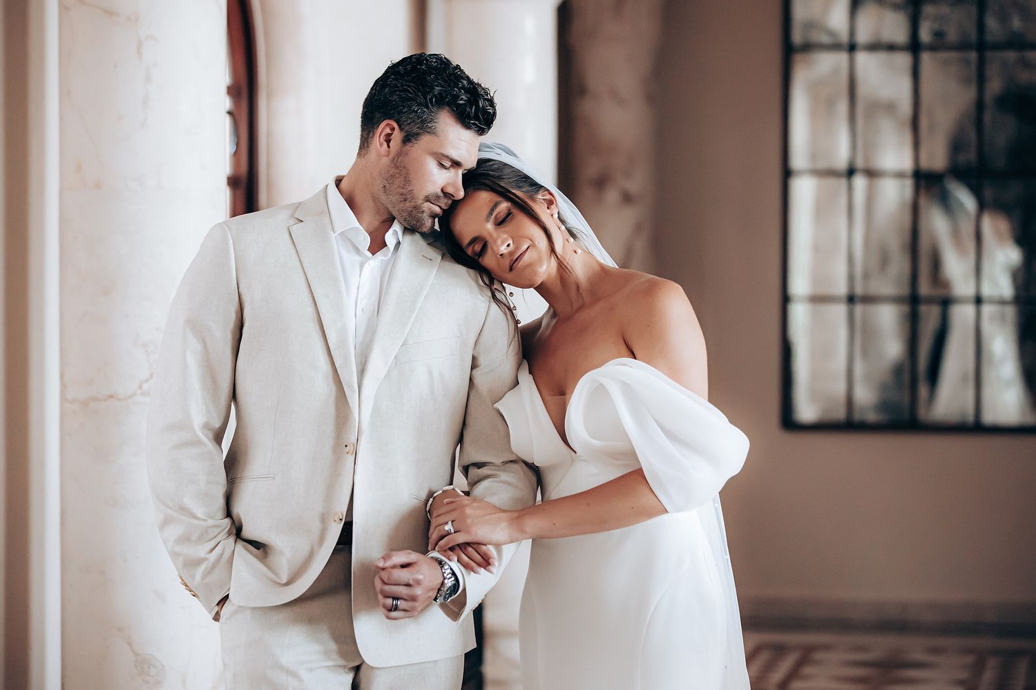 Romantic wedding moments captured in an elegant indoor venue with white decor.