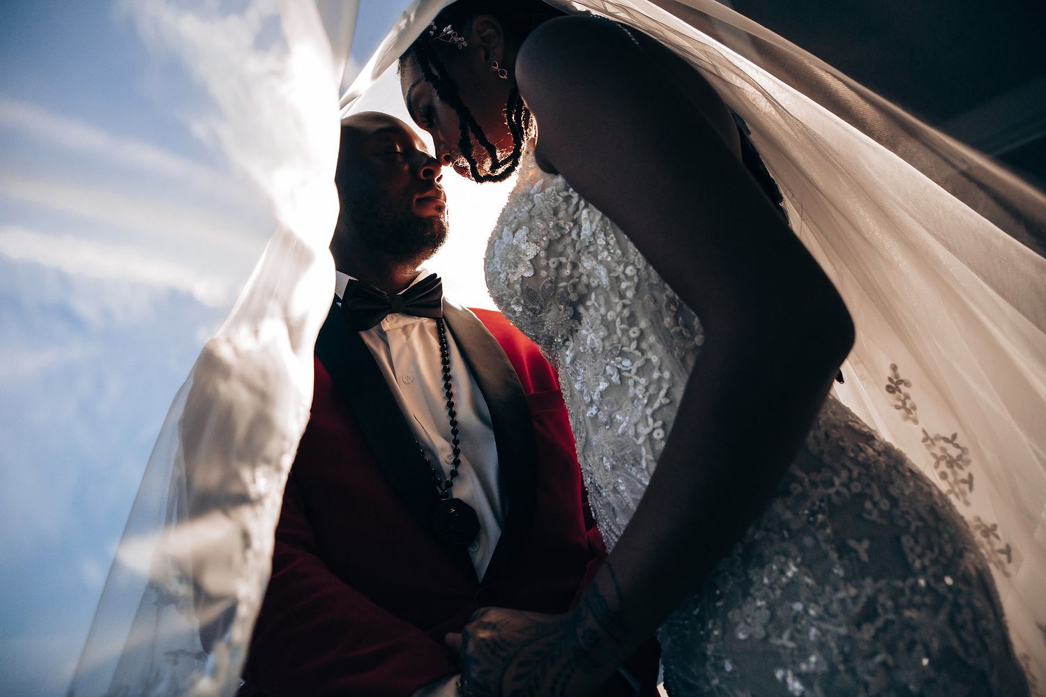 Dramatic silhouette wedding photography sequence showing intimate moments between couple against bright sky.