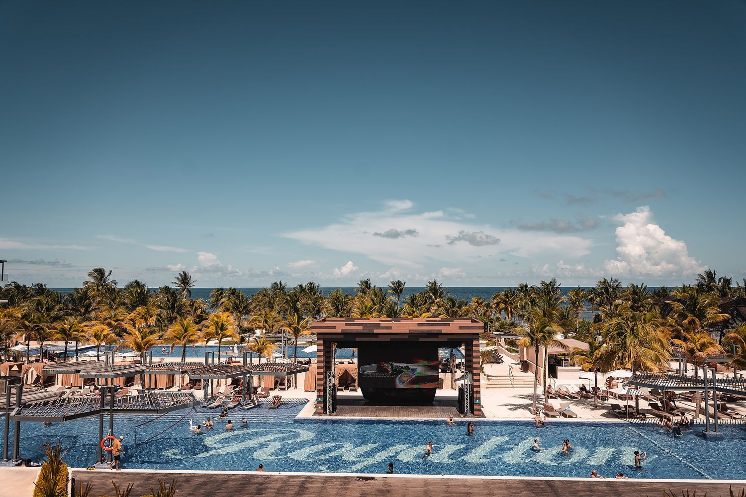 A panoramic collage of tropical marina scenes showing boats, docks, and palm trees against a blue sky.