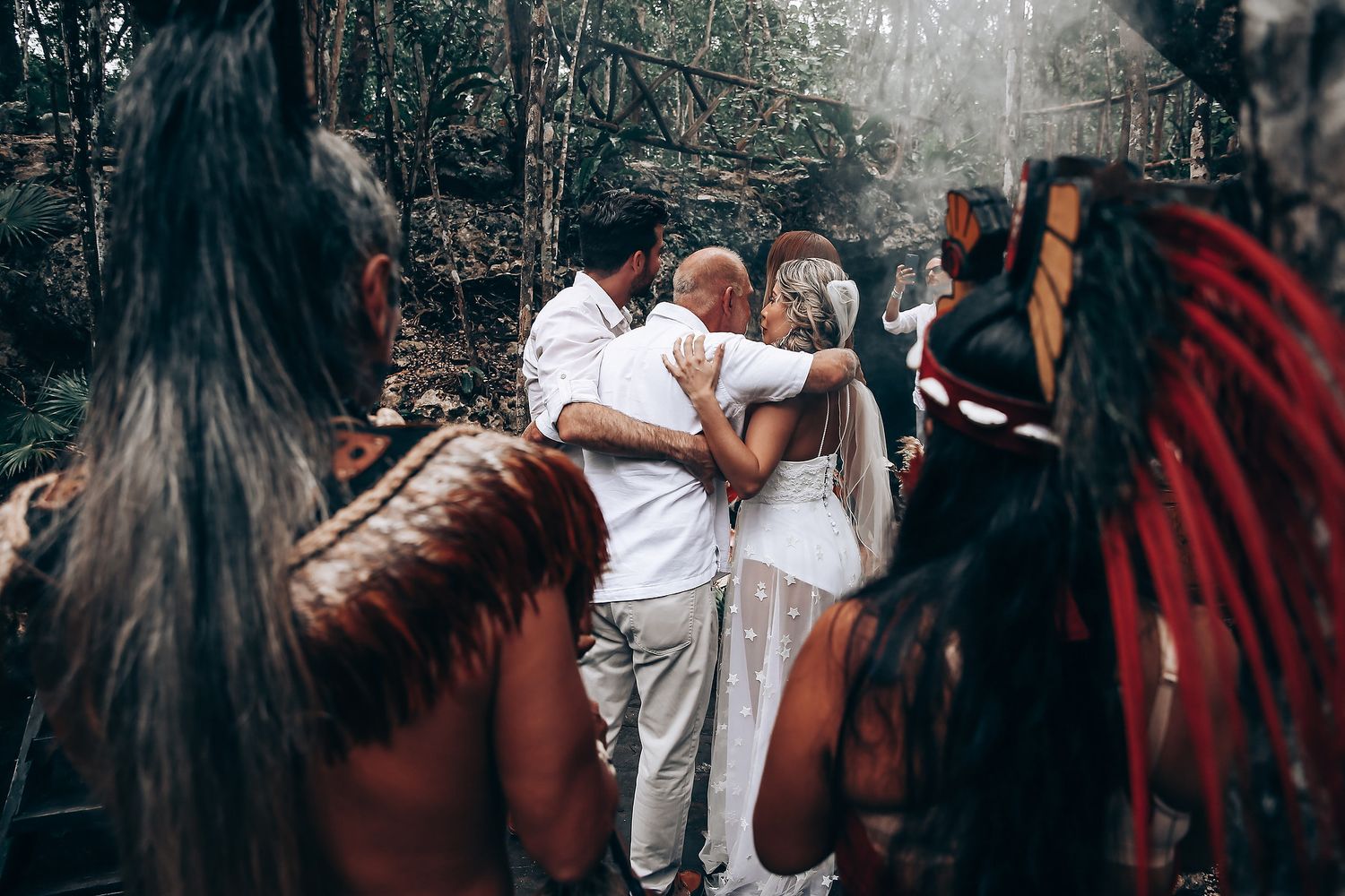 People celebrating together in a lush outdoor setting with traditional decorations and attire.