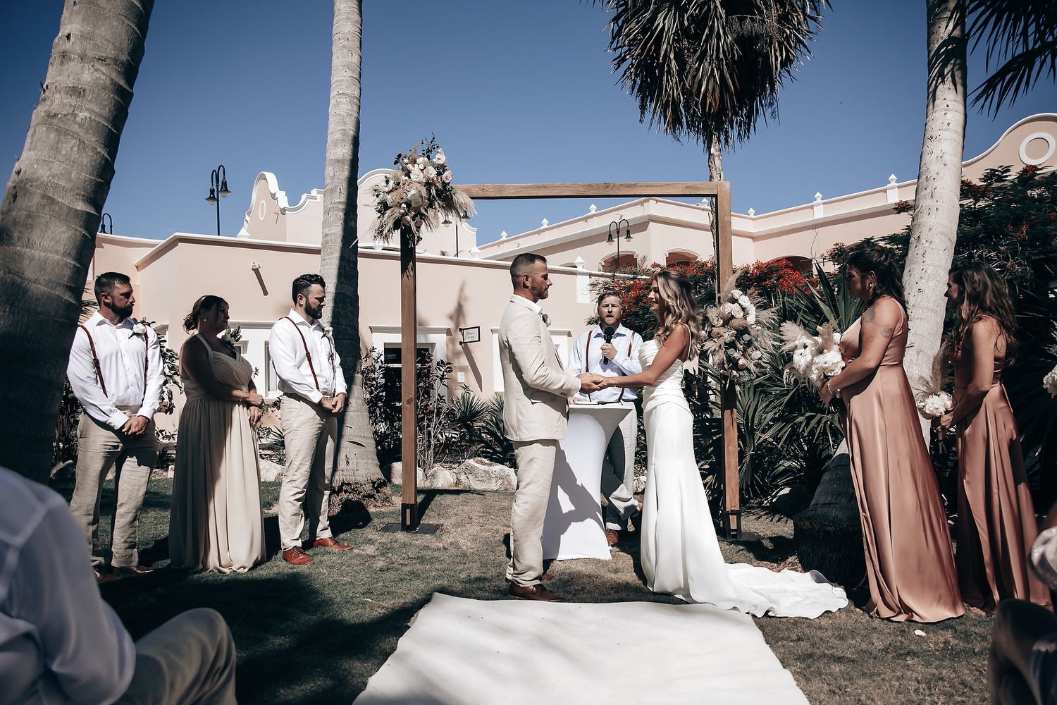 A bride and groom exchange vows during an outdoor wedding ceremony.