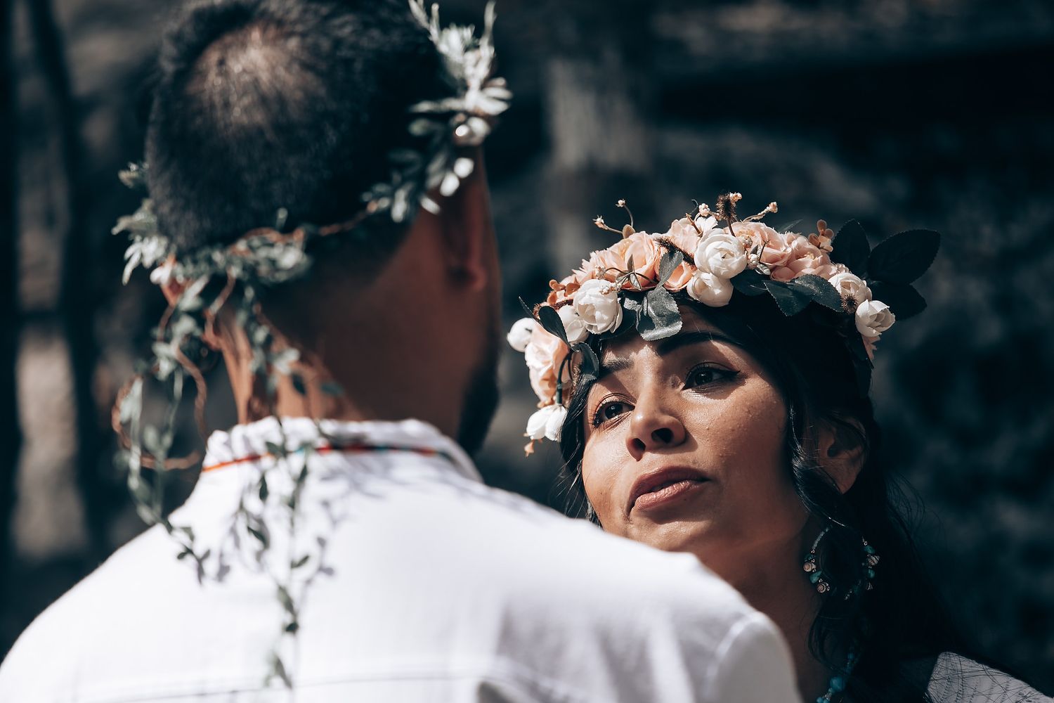 Close-up view of people wearing floral headdresses during a traditional ceremony.