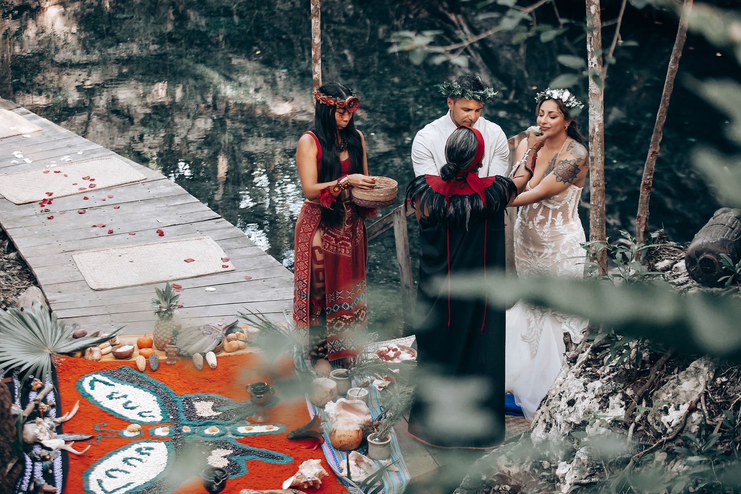 Wedding guests participate in an outdoor cultural ceremony with red accents.