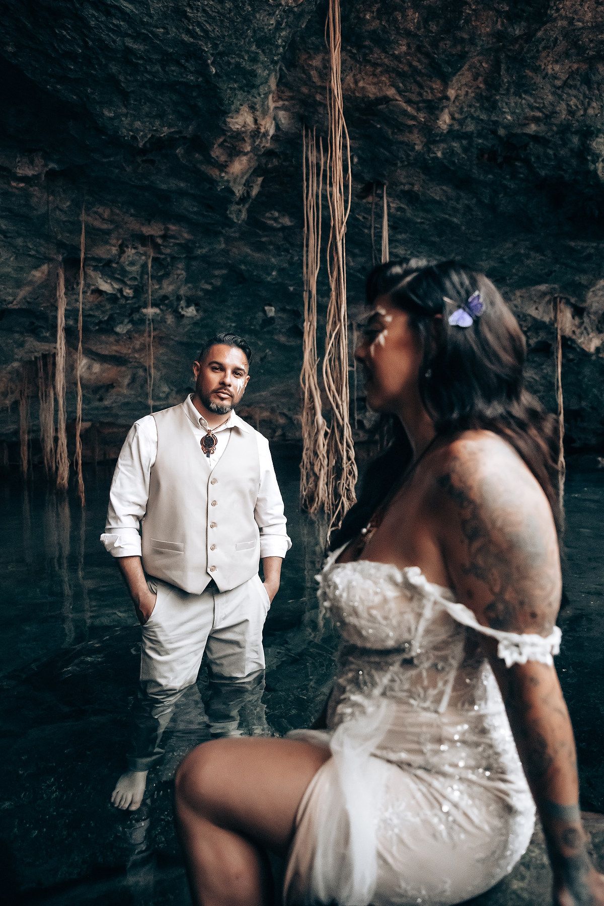A romantic wedding photo sequence showing a couple in formal attire posing in a dramatic cave setting with natural lighting.