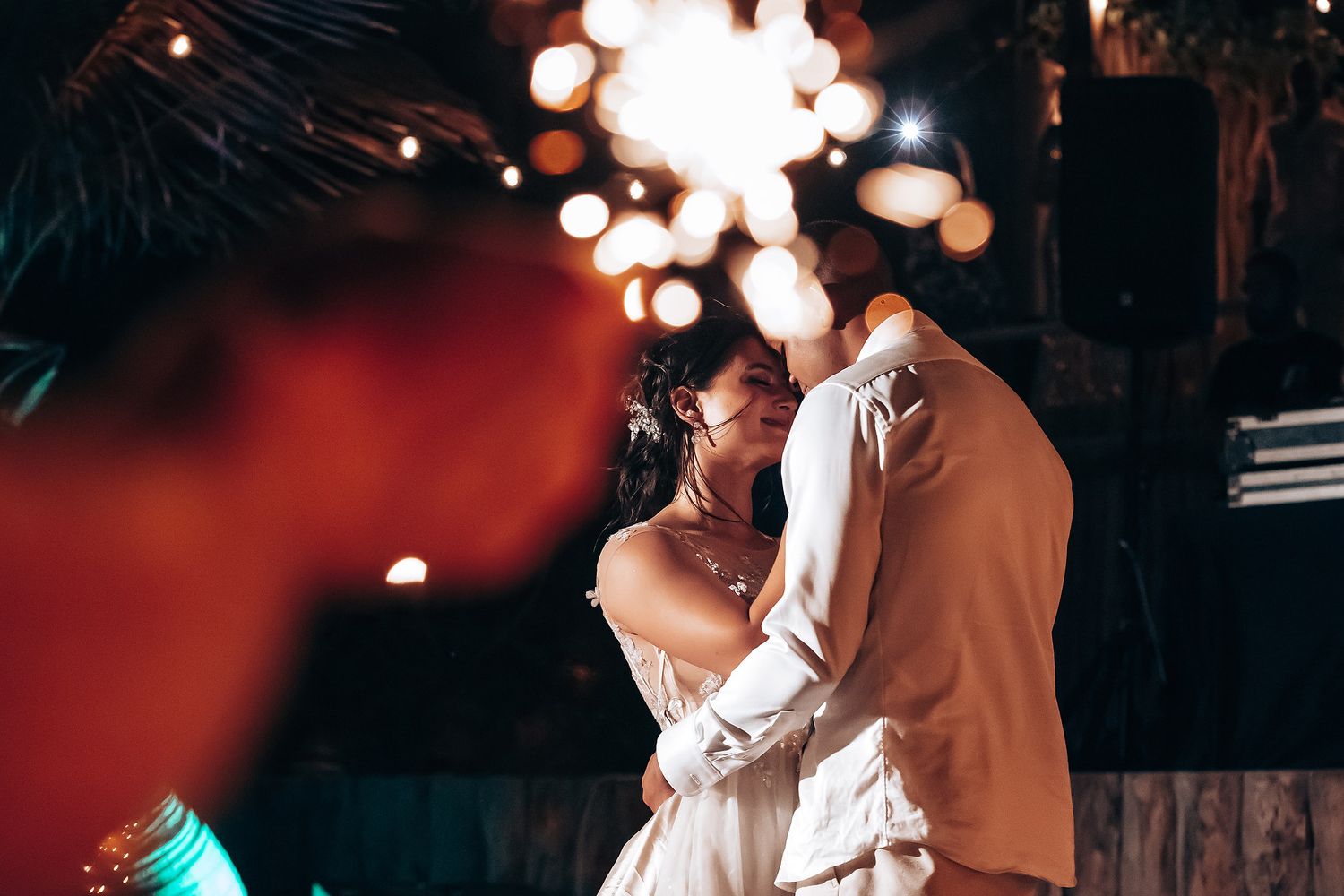 Romantic dance moments captured in dramatic lighting at an evening wedding reception.