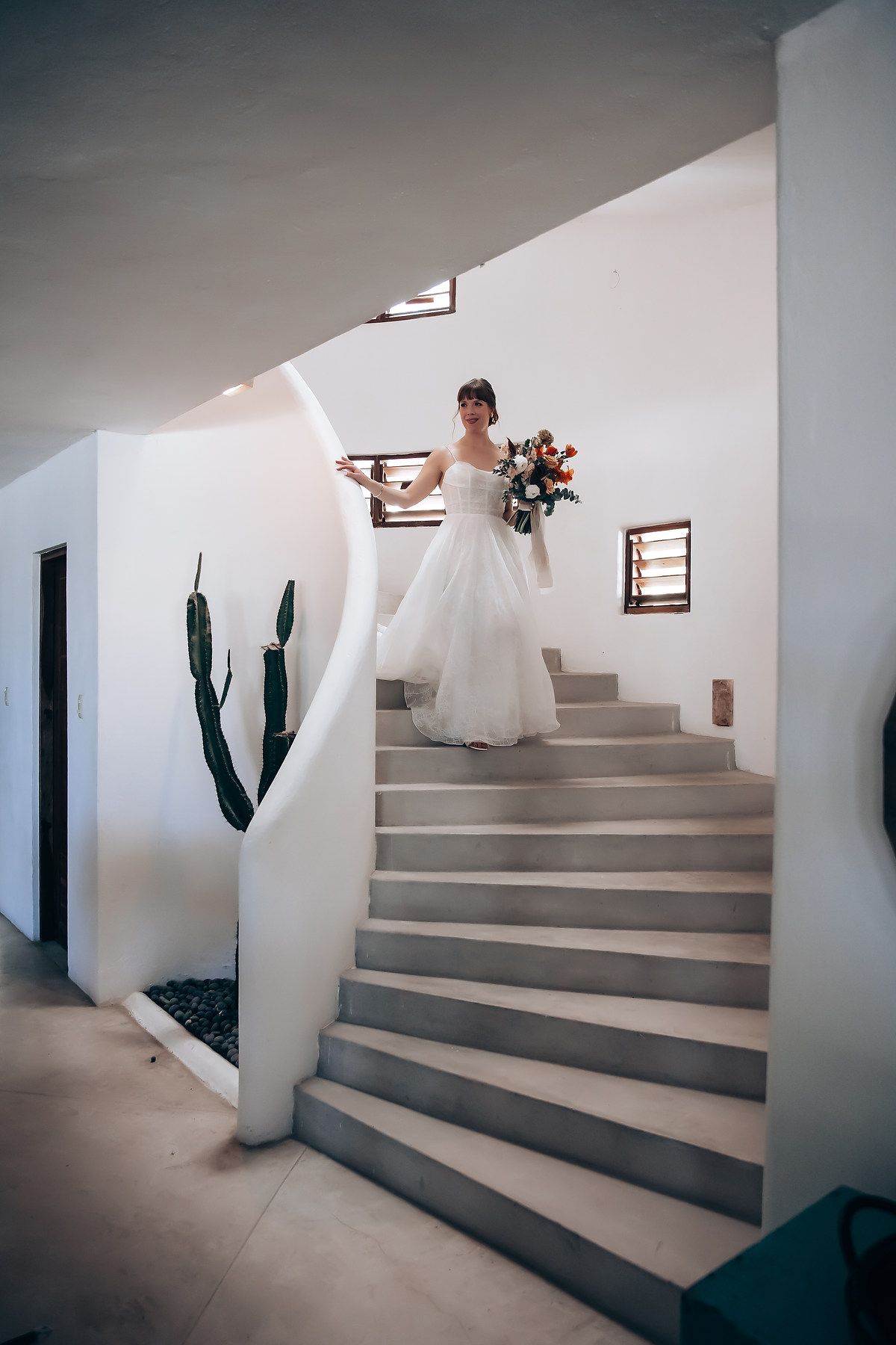 A sequence of minimalist white staircase photos with a cactus plant and wall sconces creating an architectural composition.