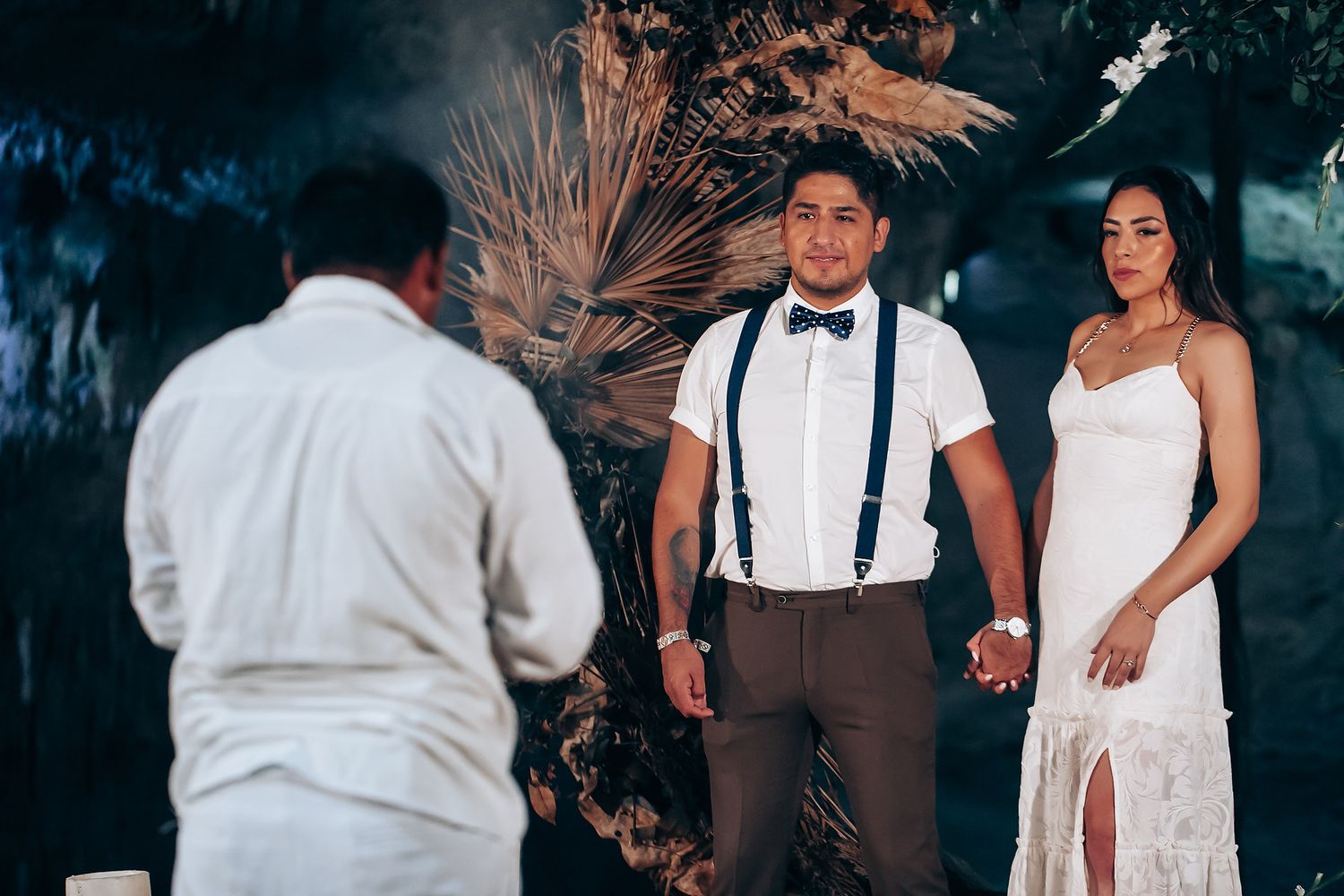 A romantic wedding celebration at dusk with a couple dancing in an outdoor venue decorated with string lights.