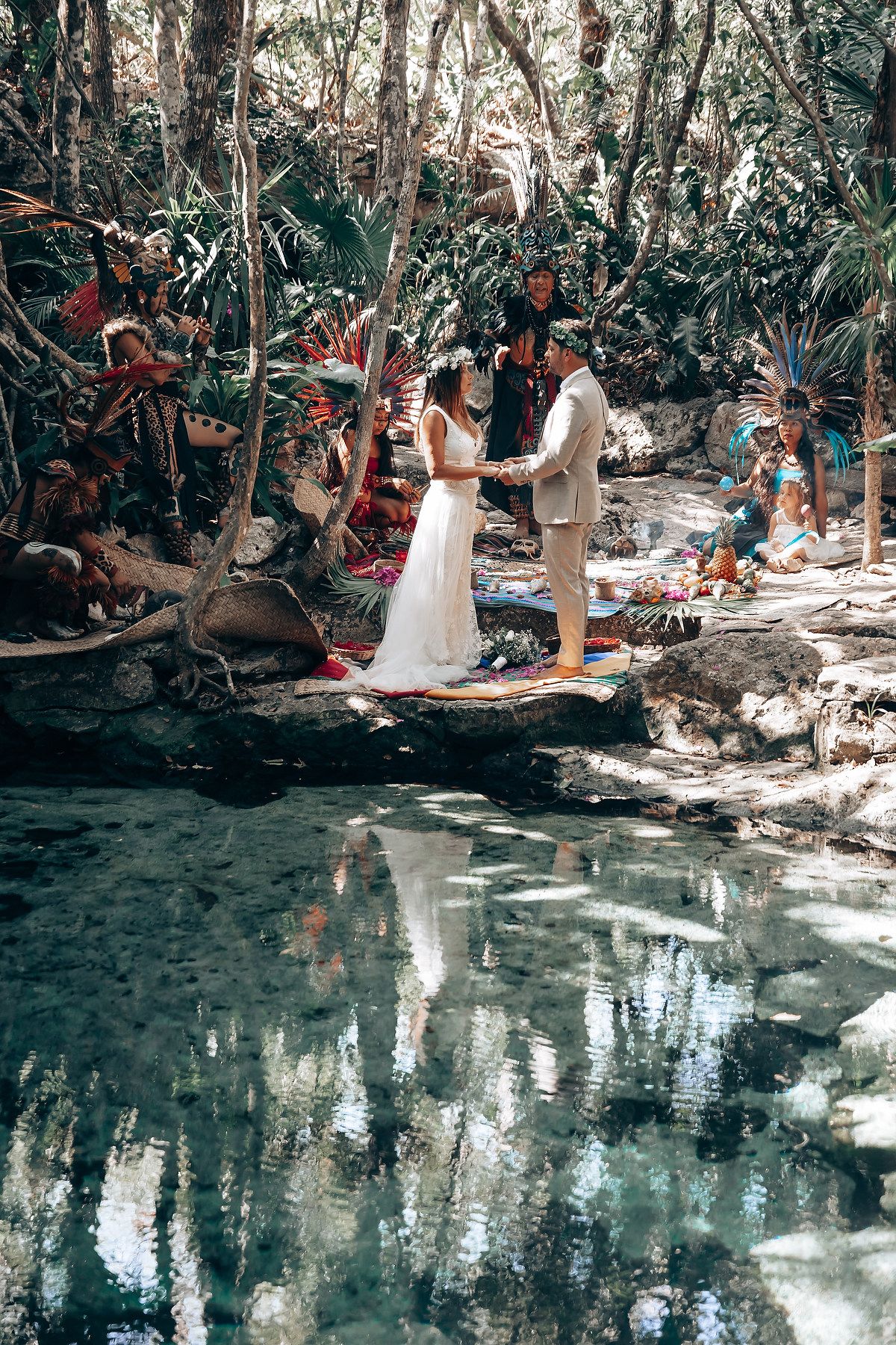 Sacred Mayan ceremony taking place beside a tranquil cenote with reflective waters.