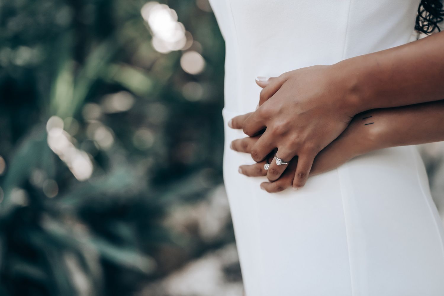 Detail shot of hands touching during an intimate wedding moment outdoors.