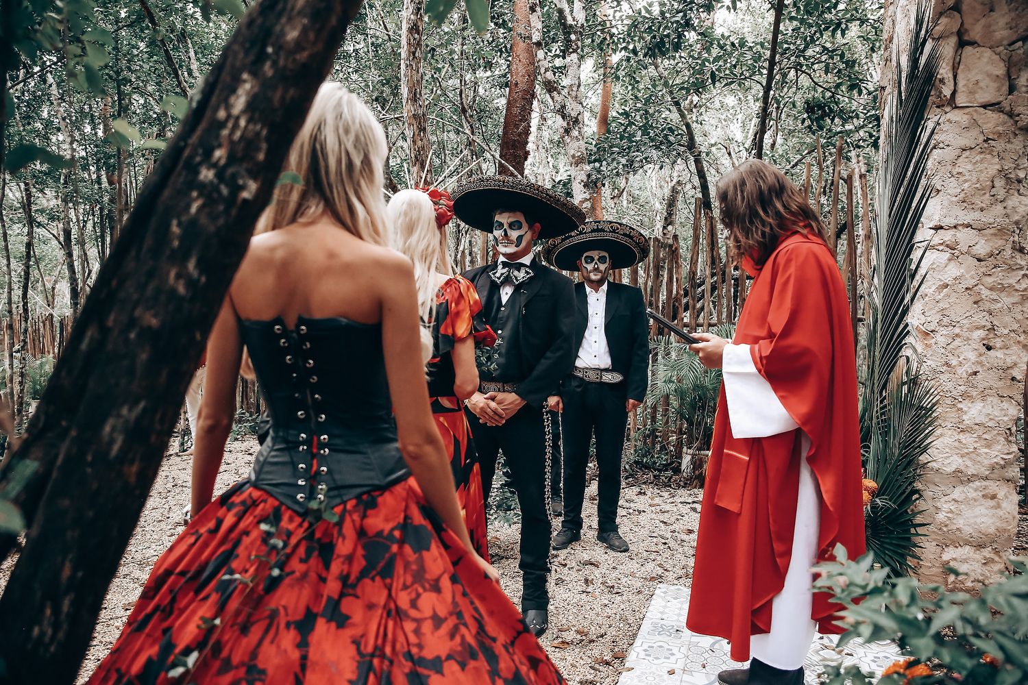 Outdoor wedding gathering with gothic and Day of the Dead themed decorations.