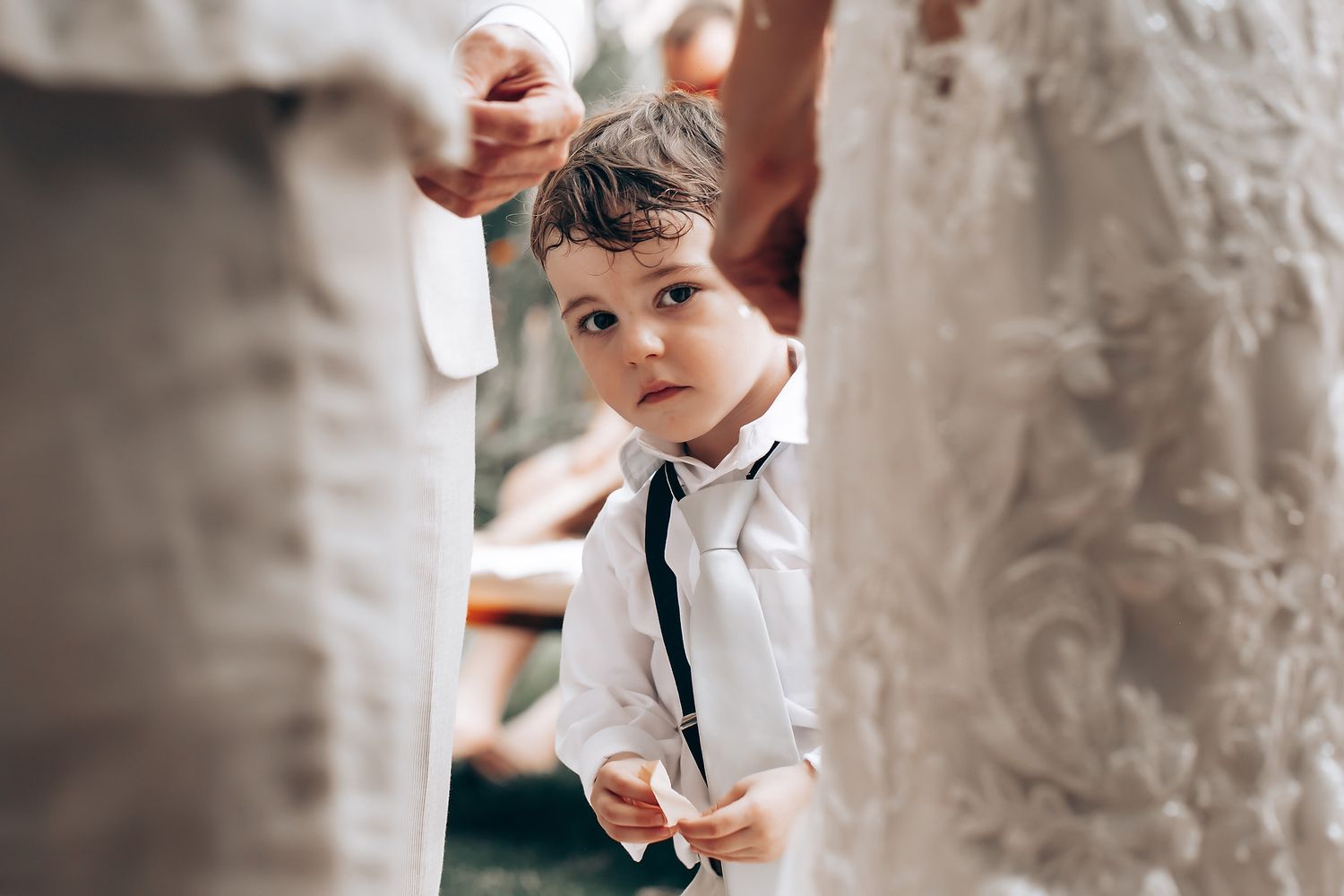 Close-up details of elegant white wedding attire with delicate lace patterns.