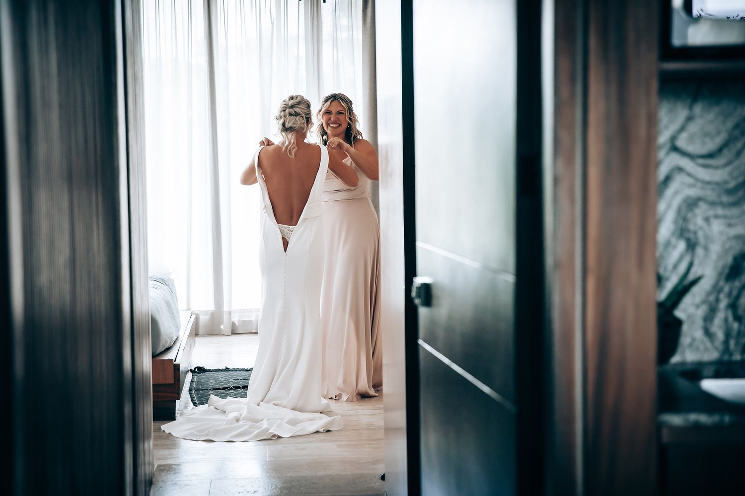 Wedding preparations scene with elegant white dresses hanging in a softly lit room.