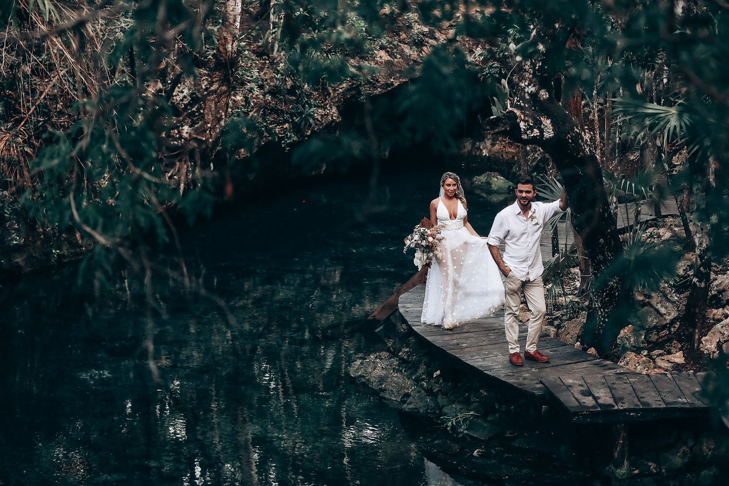 Wedding ceremony participants gathered in a mystical forest setting with filtered light.
