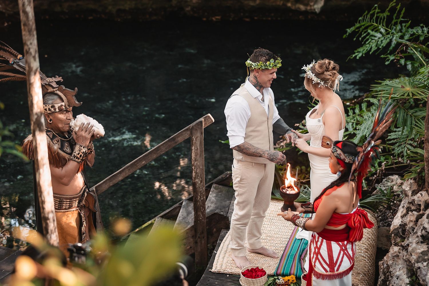 Couple exchanges vows in a Mayan cenote wedding ceremony with indigenous officiant and fire ritual in lush jungle setting.