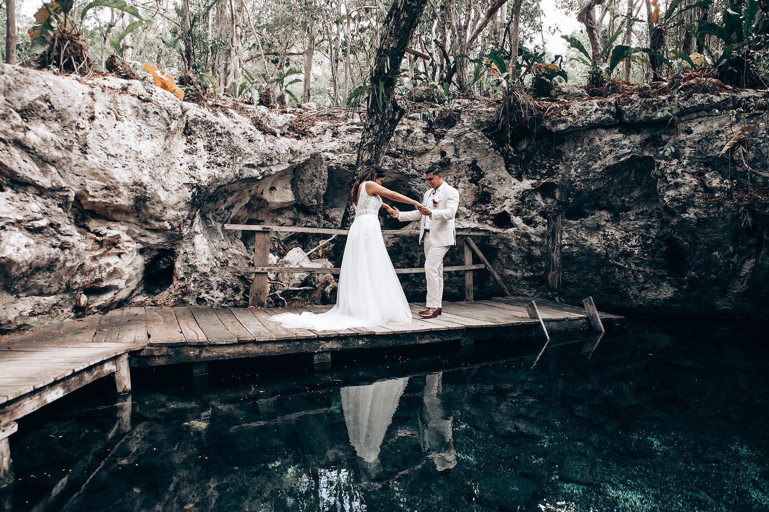 Scenic cave wedding ceremony overlooking crystal clear cenote waters in Mexico.