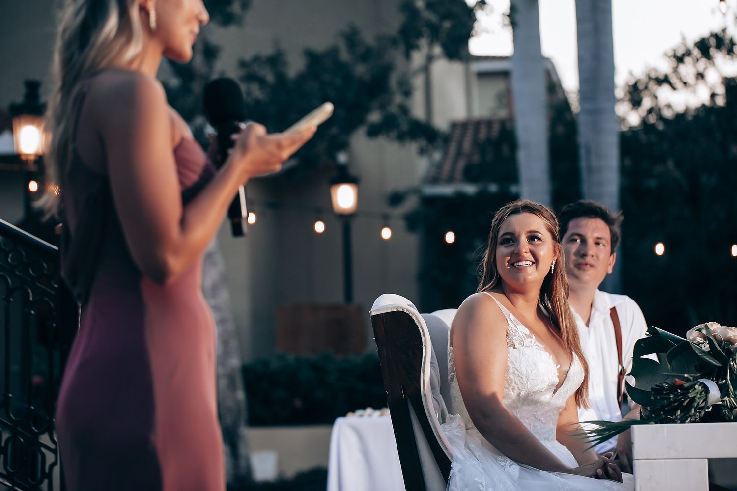 Evening wedding reception with string lights and guests enjoying outdoor celebration.
