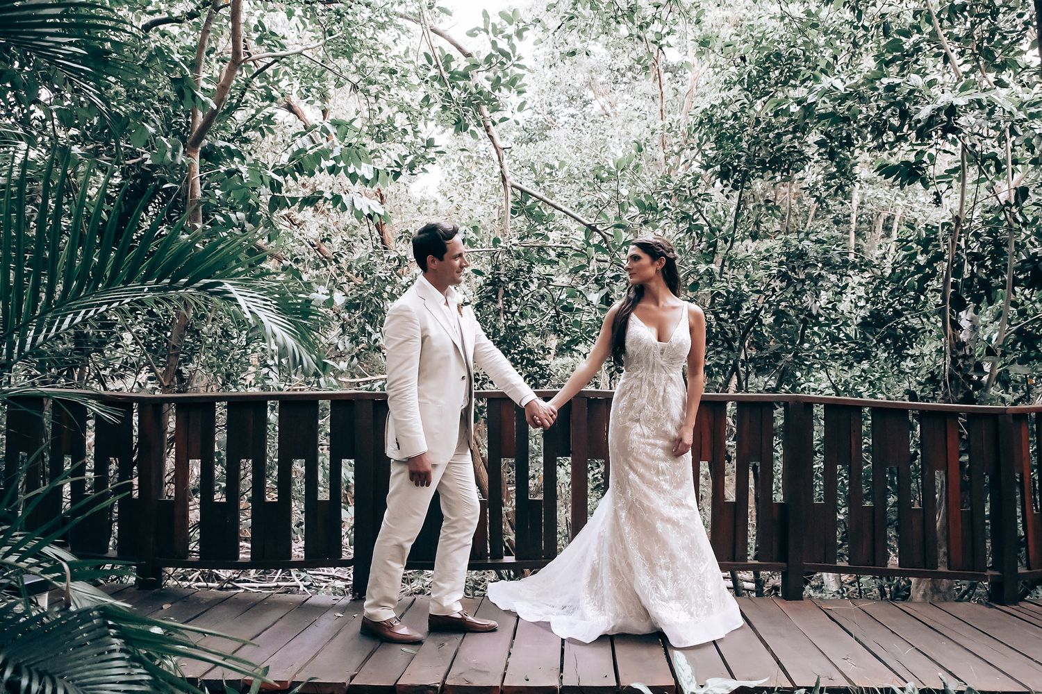 Wedding couple sharing intimate moments in a lush tropical garden setting.