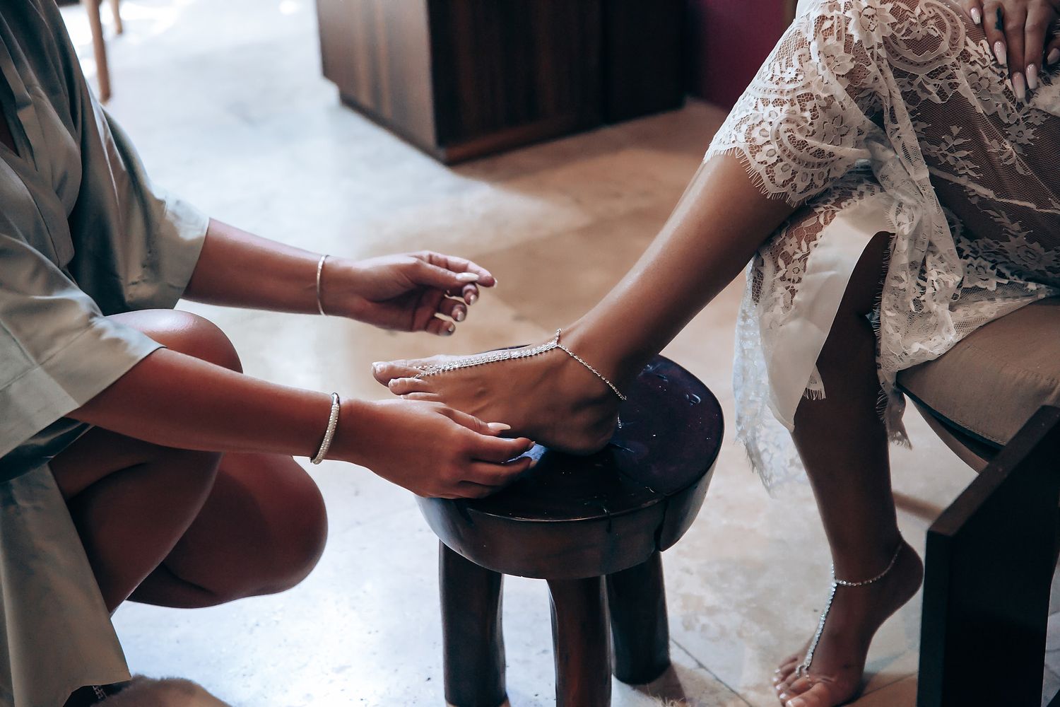 Close-up of hands during wedding preparation showing delicate lace details.