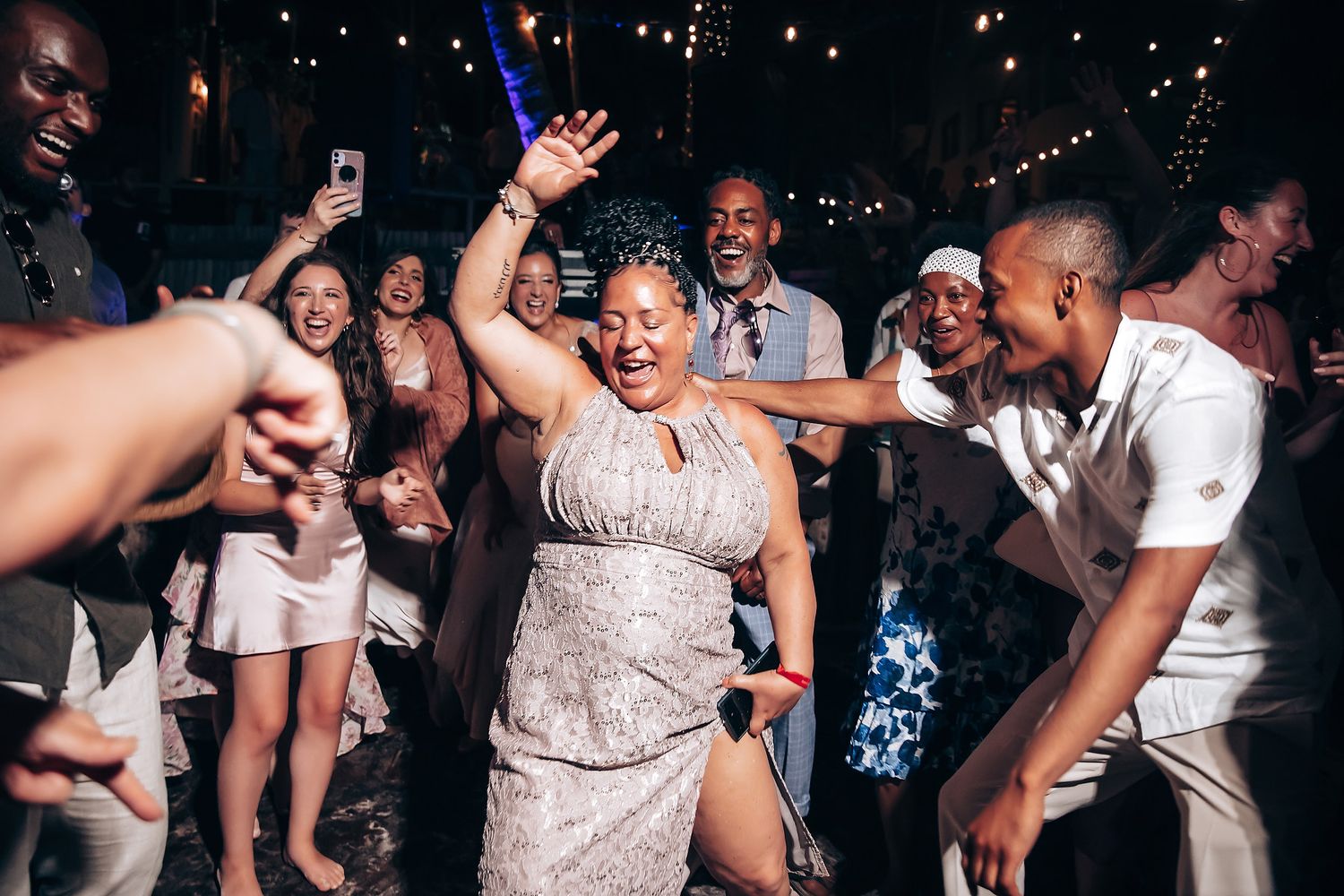Lively dance party at a wedding reception with guests enjoying the celebration.