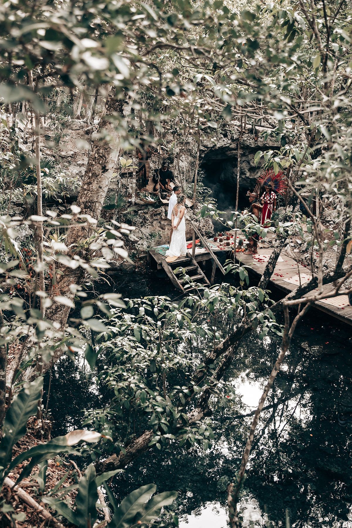 Aerial view of a forest ceremony space with wooden platforms surrounded by lush vegetation.