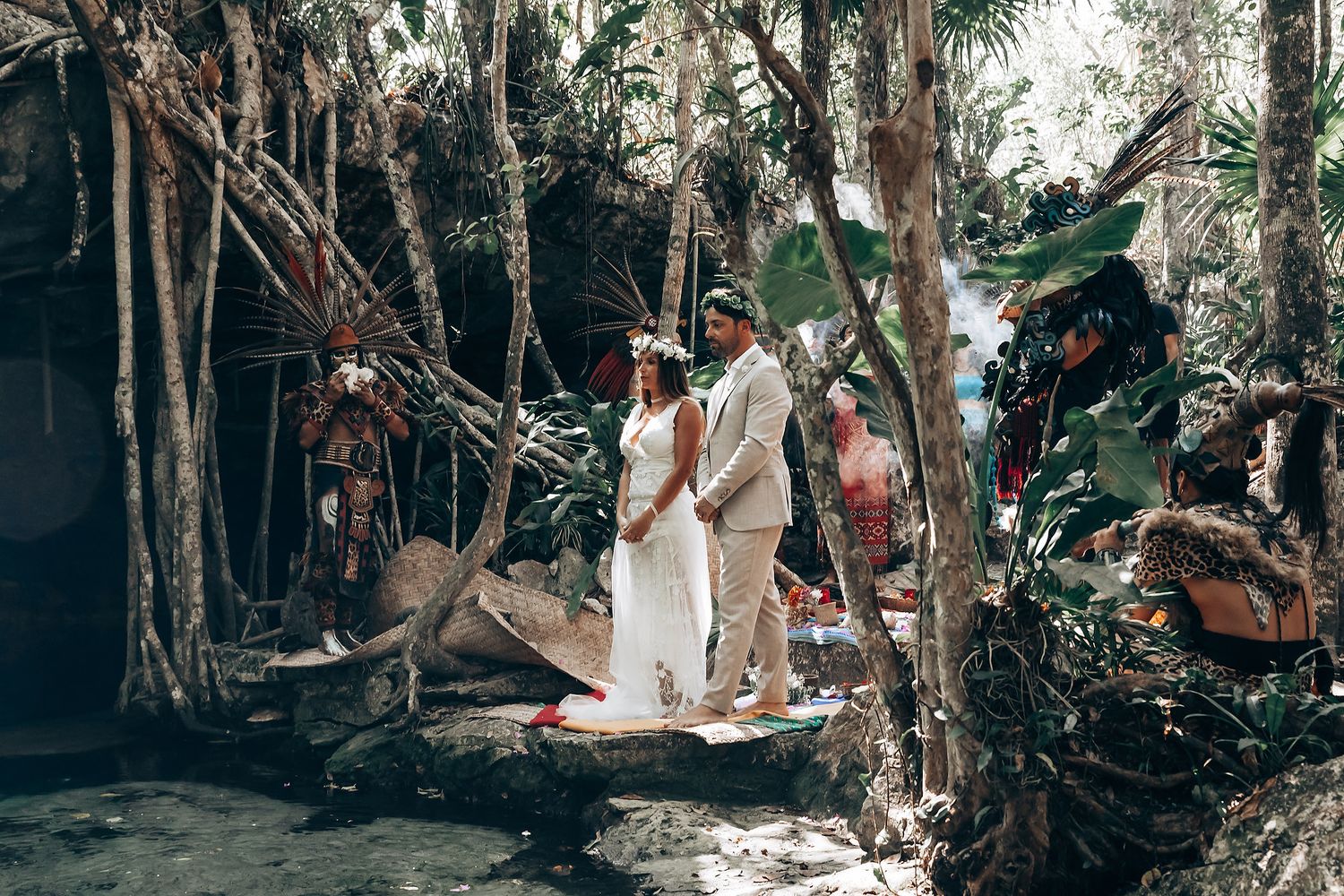 Forest wedding ceremony with guests gathered among tall trees and natural greenery.