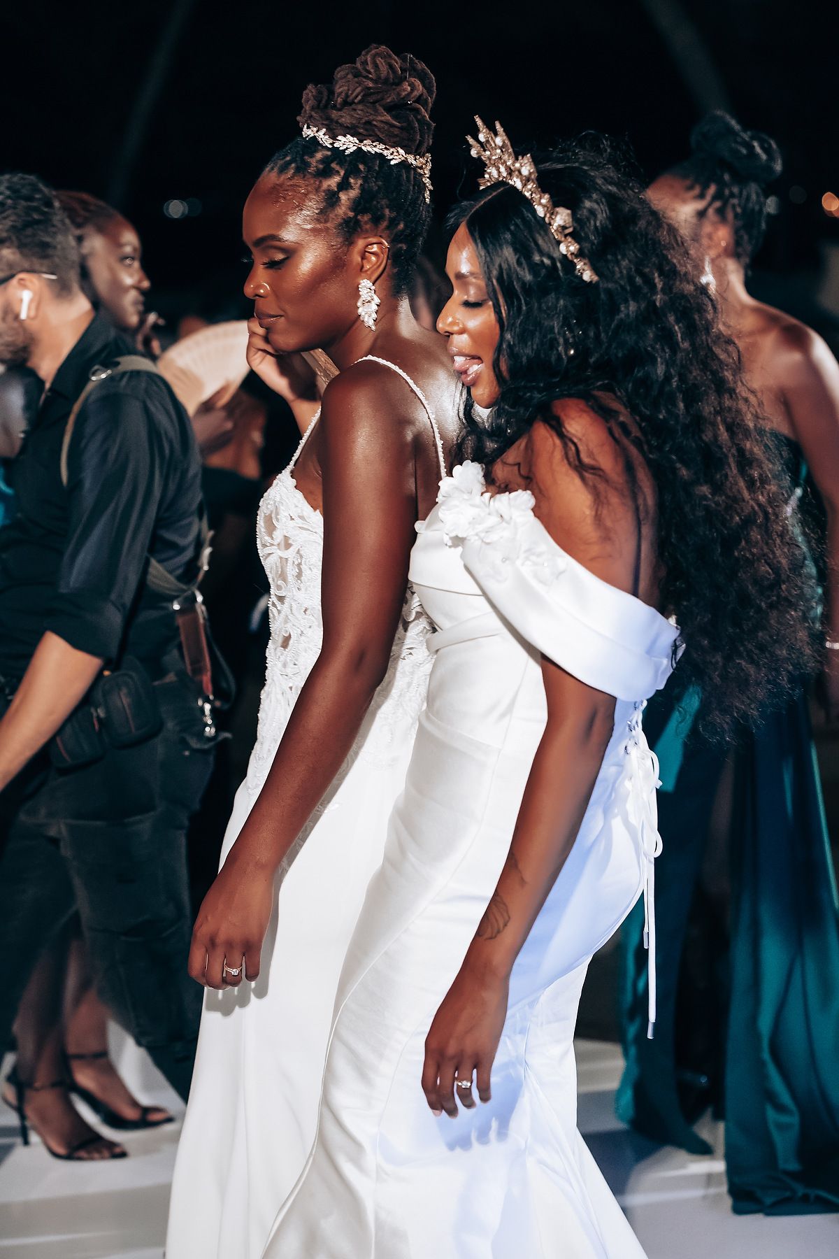 Wedding celebration on a dance floor with elegant white gowns and formal attire.