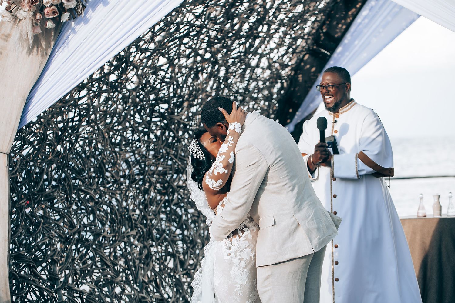 Wedding ceremony moments captured under an elegant arch with black and white decor.