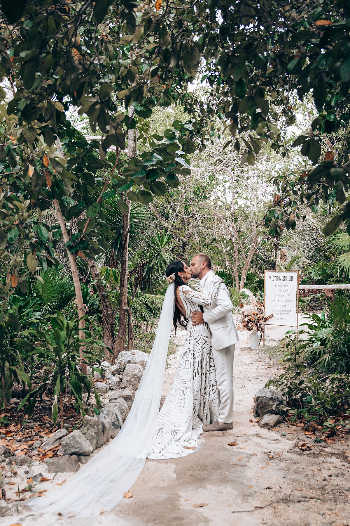 A couple in wedding attire shares romantic moments along a garden path in a series of candid shots.