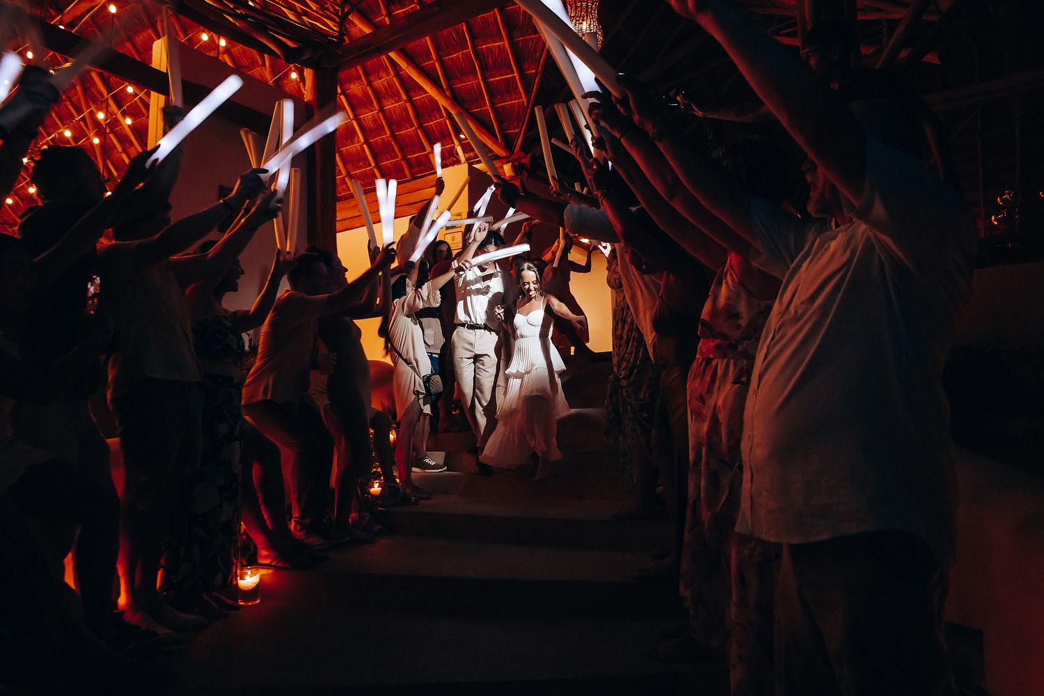 Romantic first dance moment captured under warm red lighting at wedding reception.