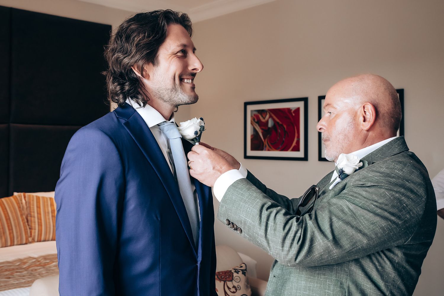 A heartwarming moment between two men in formal attire sharing an emotional embrace.
