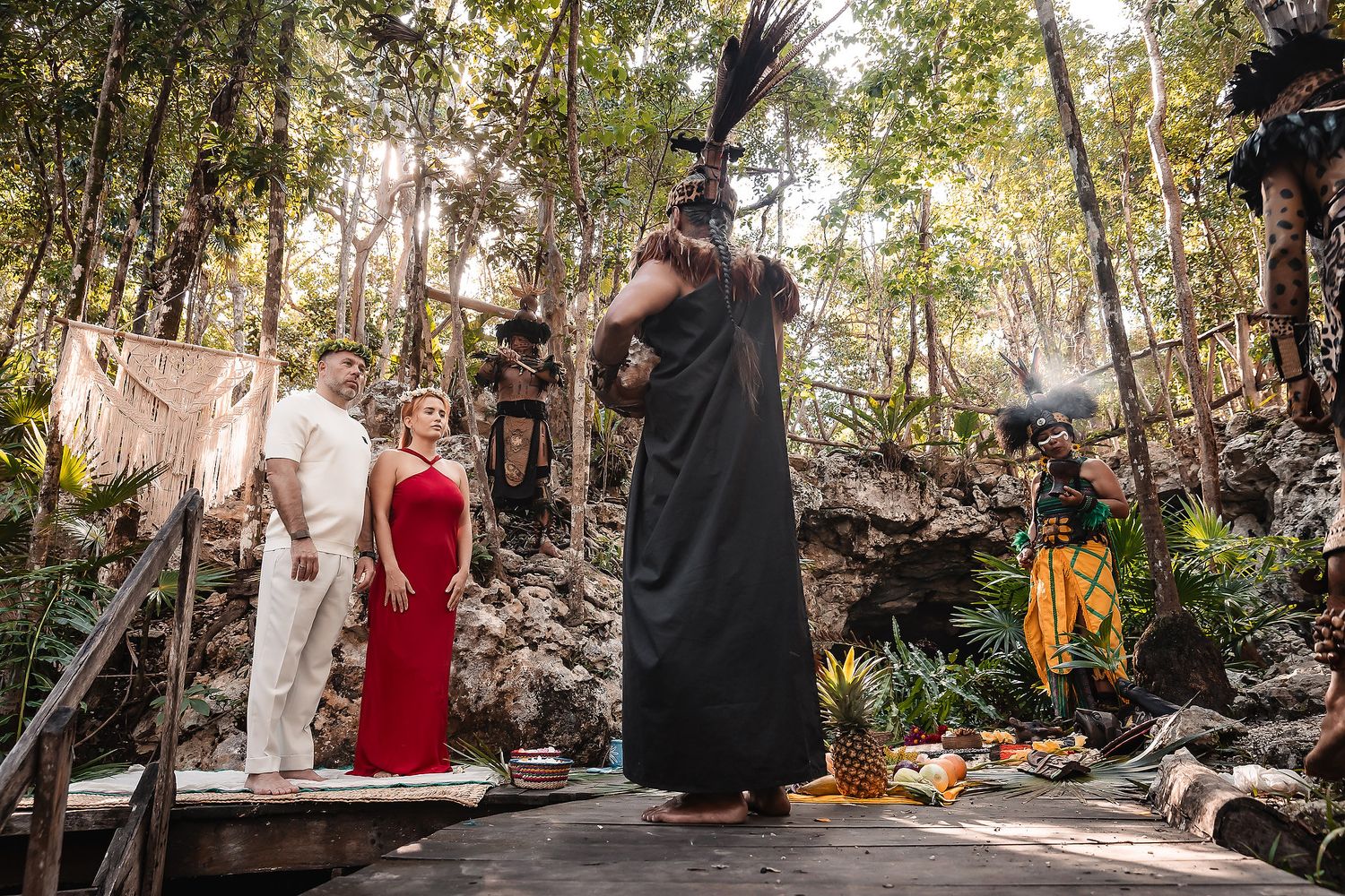 A wedding ceremony being photographed in a natural cave setting with traditional elements.