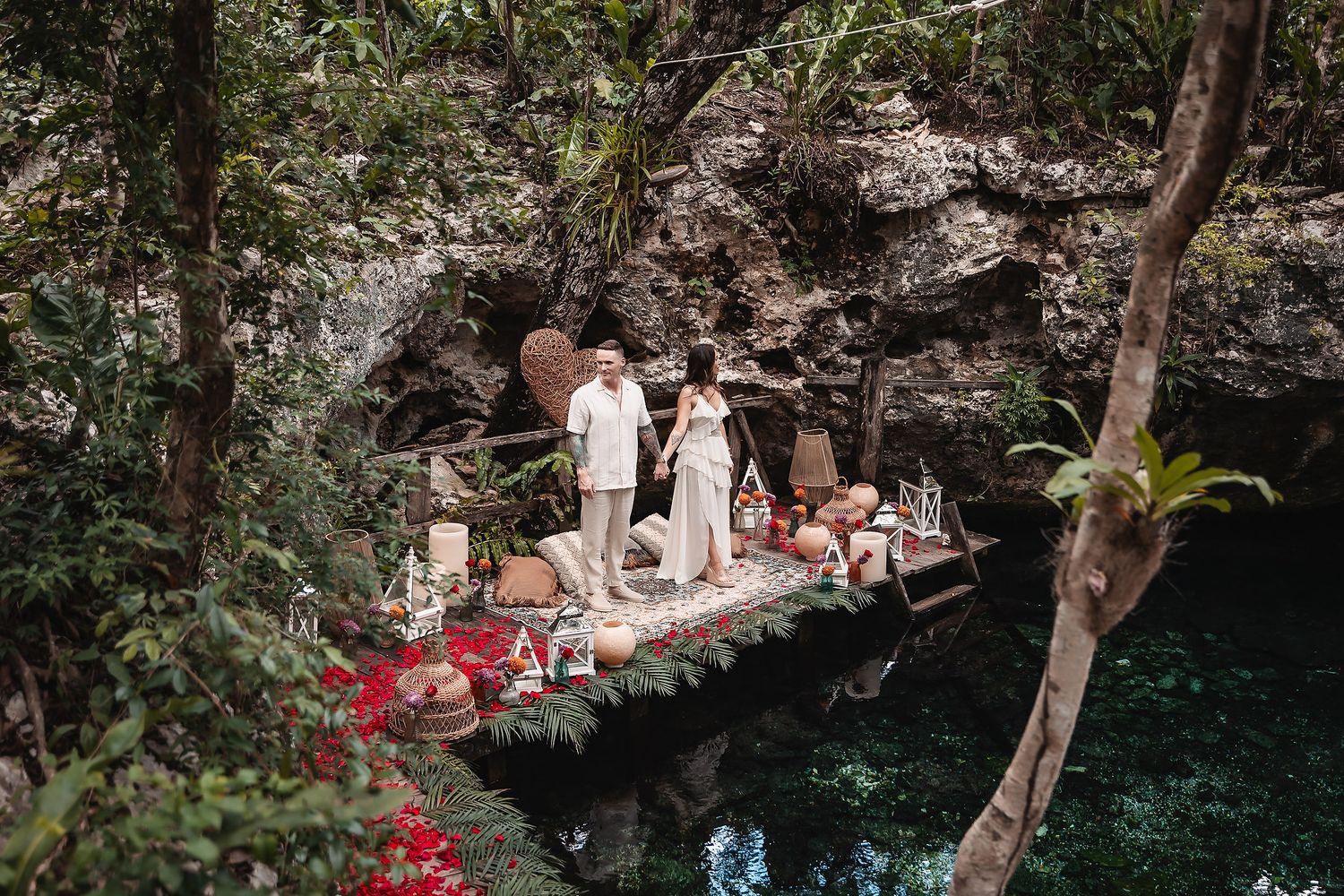 Natural garden setting with stone walls and red rose petals creating a romantic atmosphere.