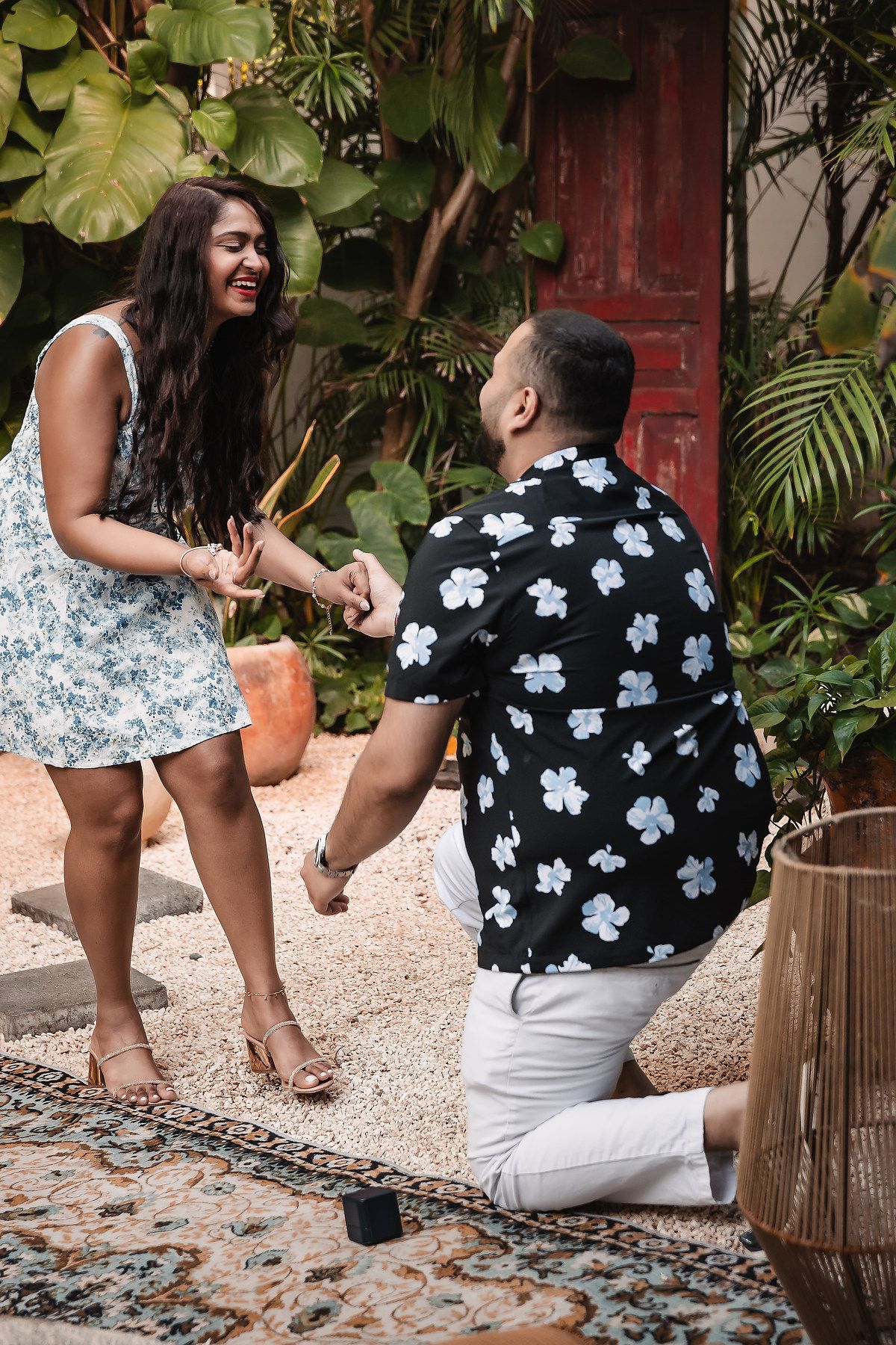 A couple in floral outfits sharing a romantic moment in a garden.