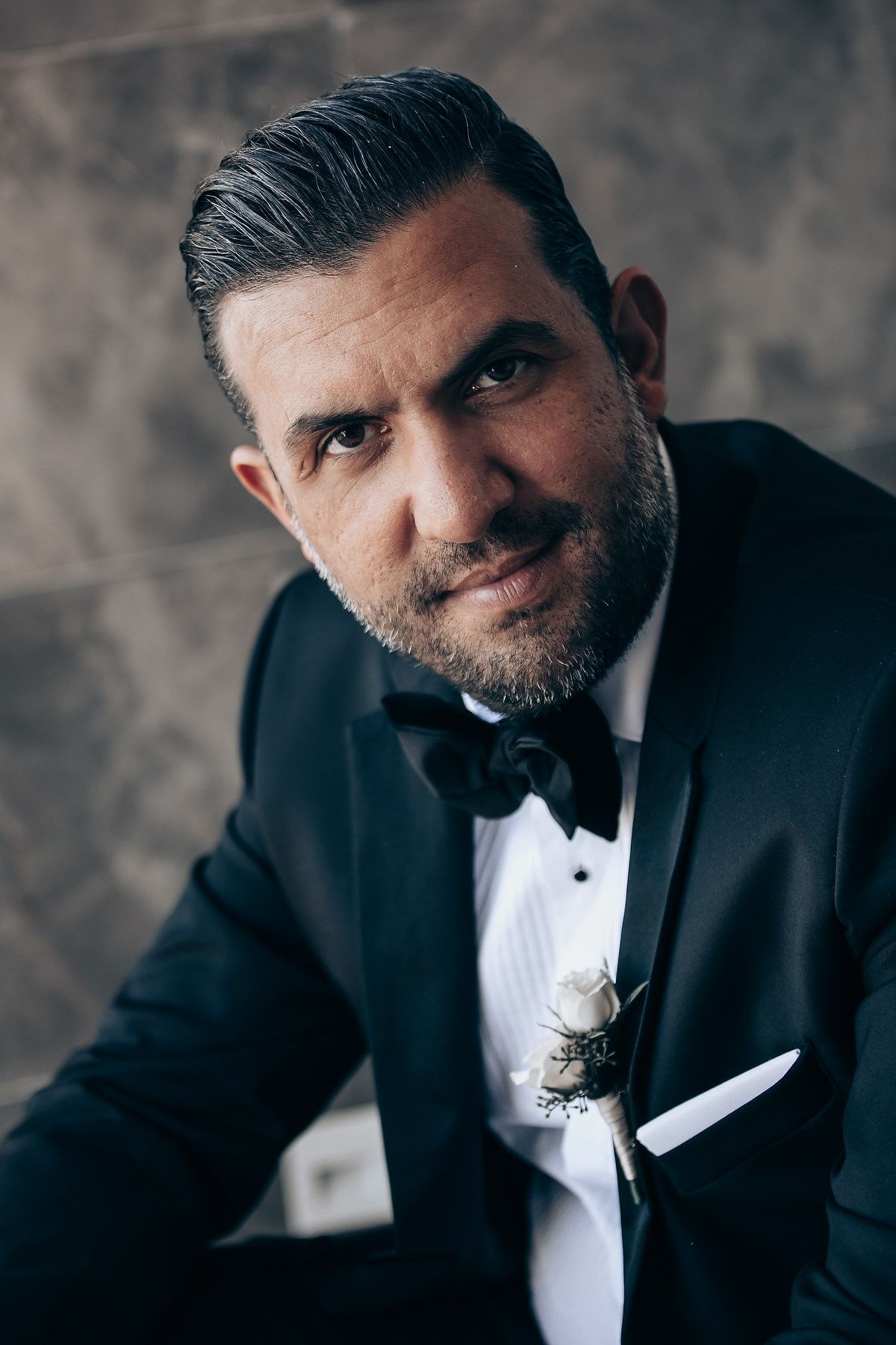 A series of black and white portraits showing a bearded man in a tuxedo with various expressions.