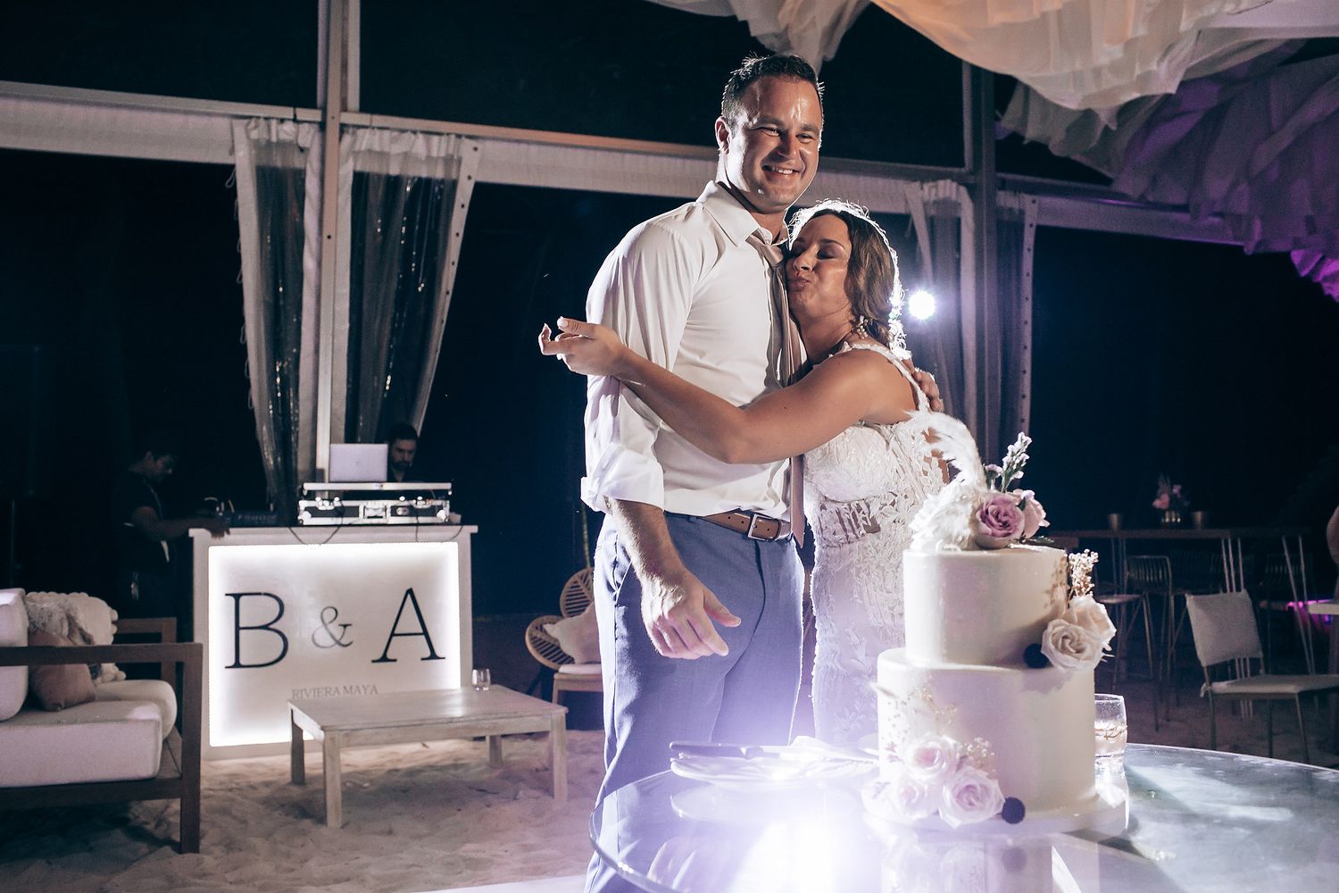 Wedding reception dance floor filled with guests celebrating under glowing string lights.