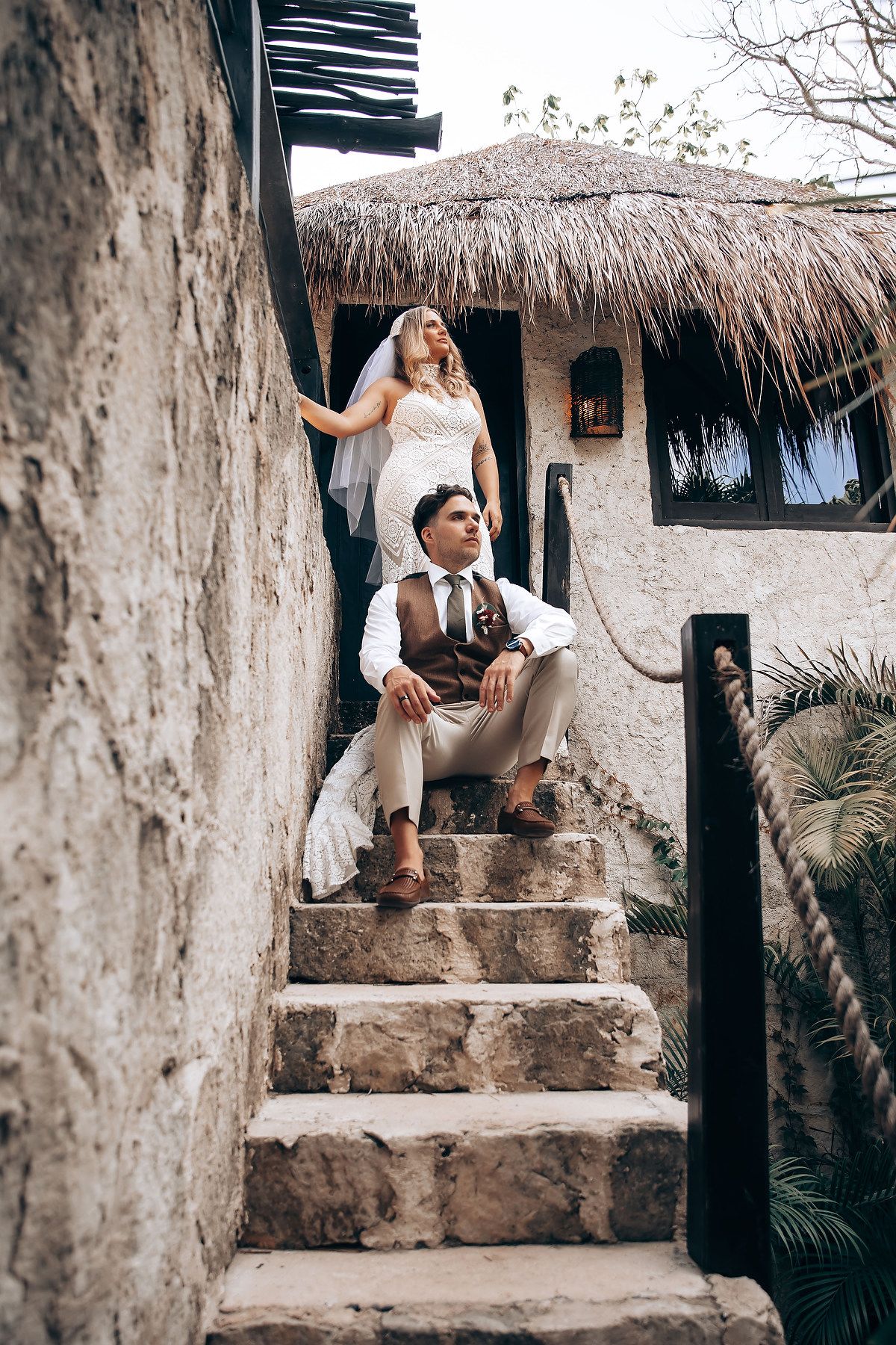 Rustic thatched-roof villa exterior with stone walls and tropical landscaping creates a serene atmosphere.