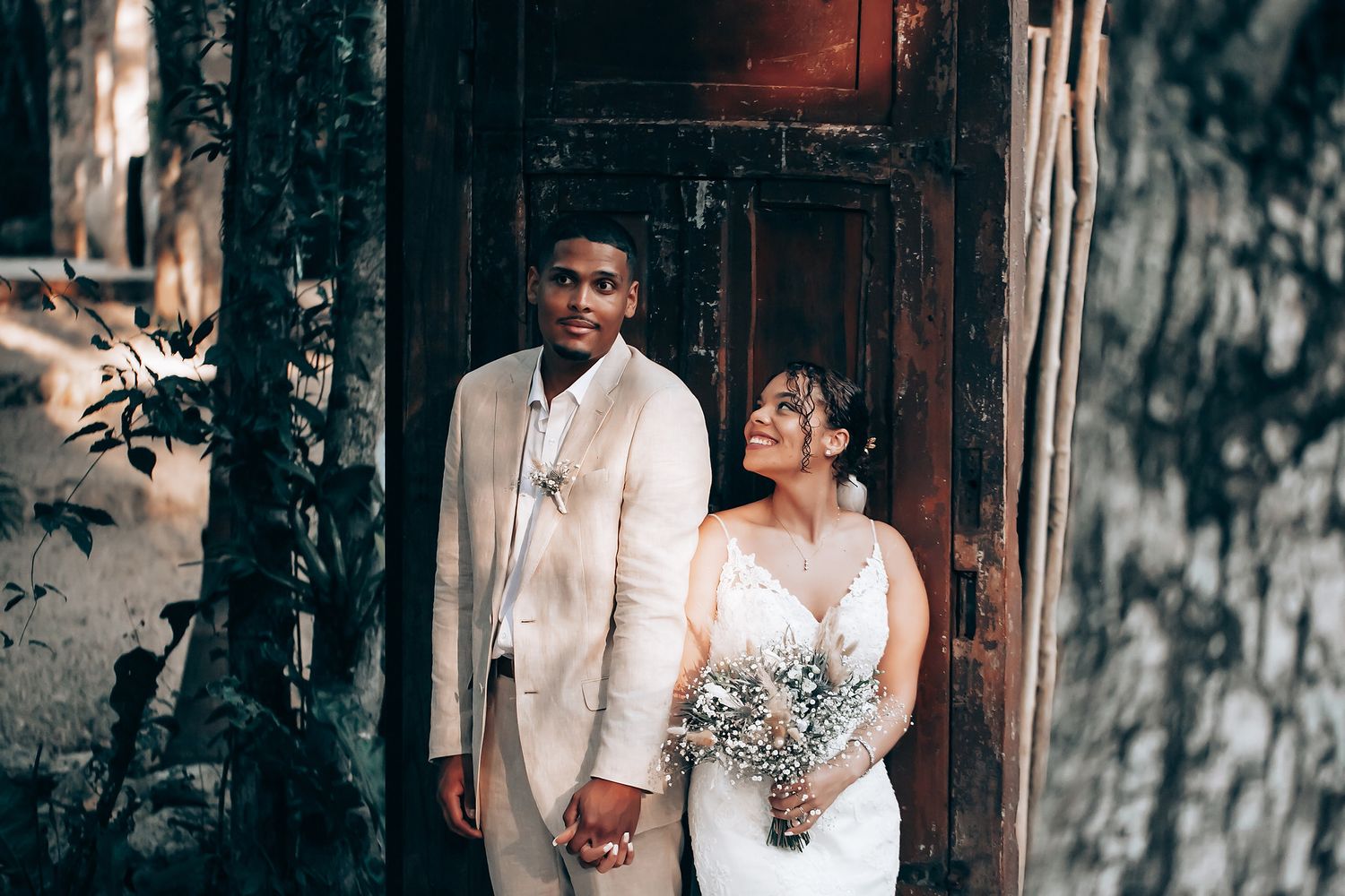 A couple shares an intimate moment during their wedding photoshoot in a rustic outdoor setting.