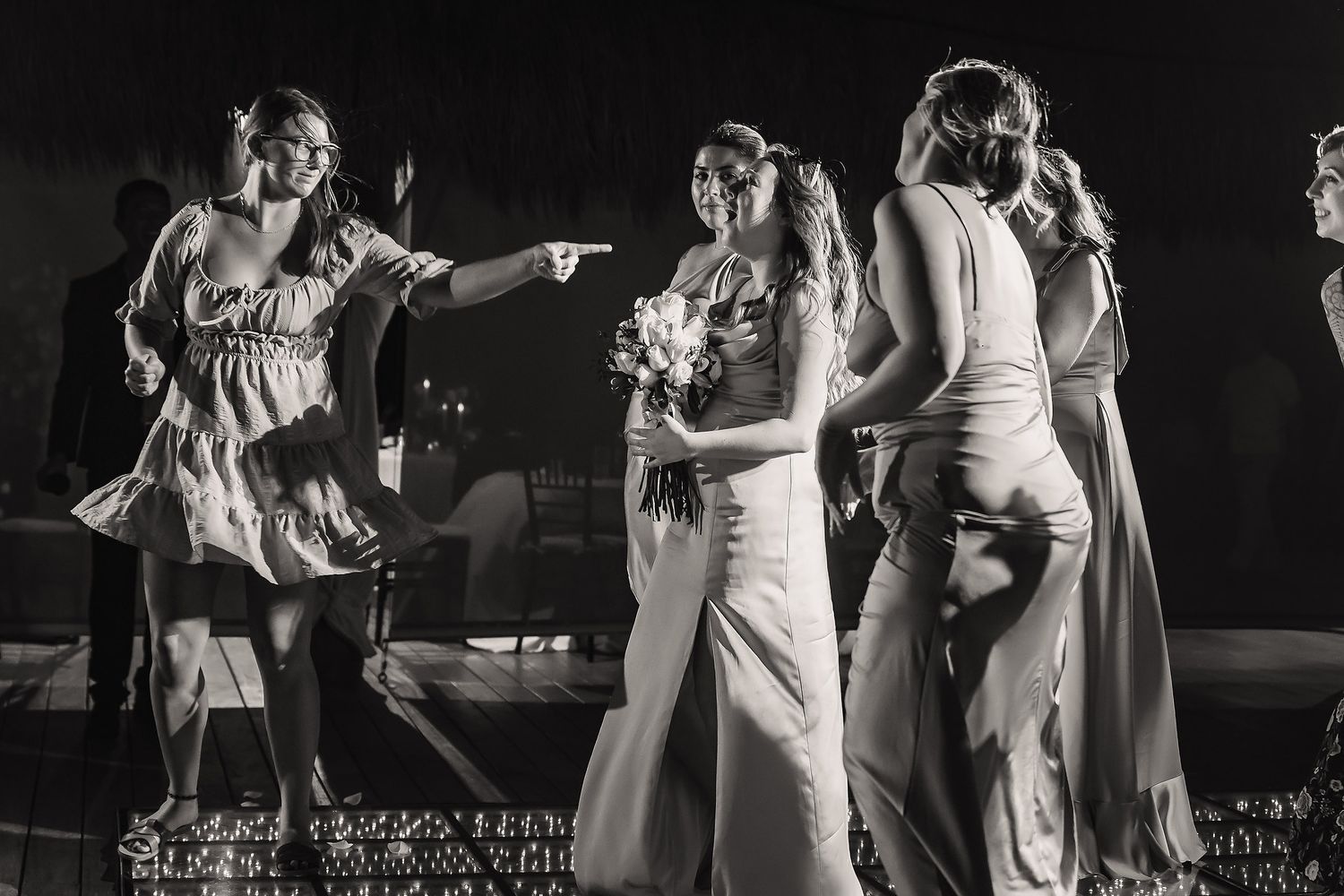 Black and white photo of wedding guests dancing and celebrating on the dance floor.