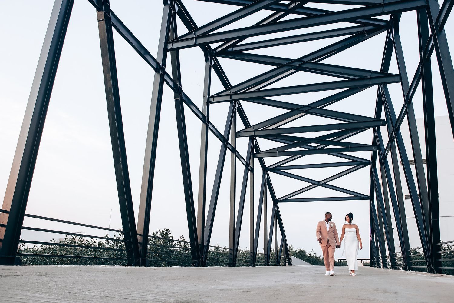 Geometric metal bridge structure creates leading lines in a minimalist architectural photograph.