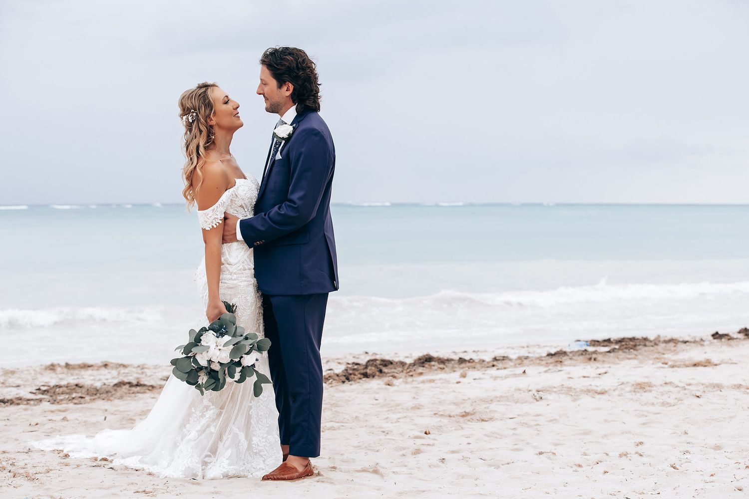 A romantic beach wedding photoshoot with the ocean waves in the background.