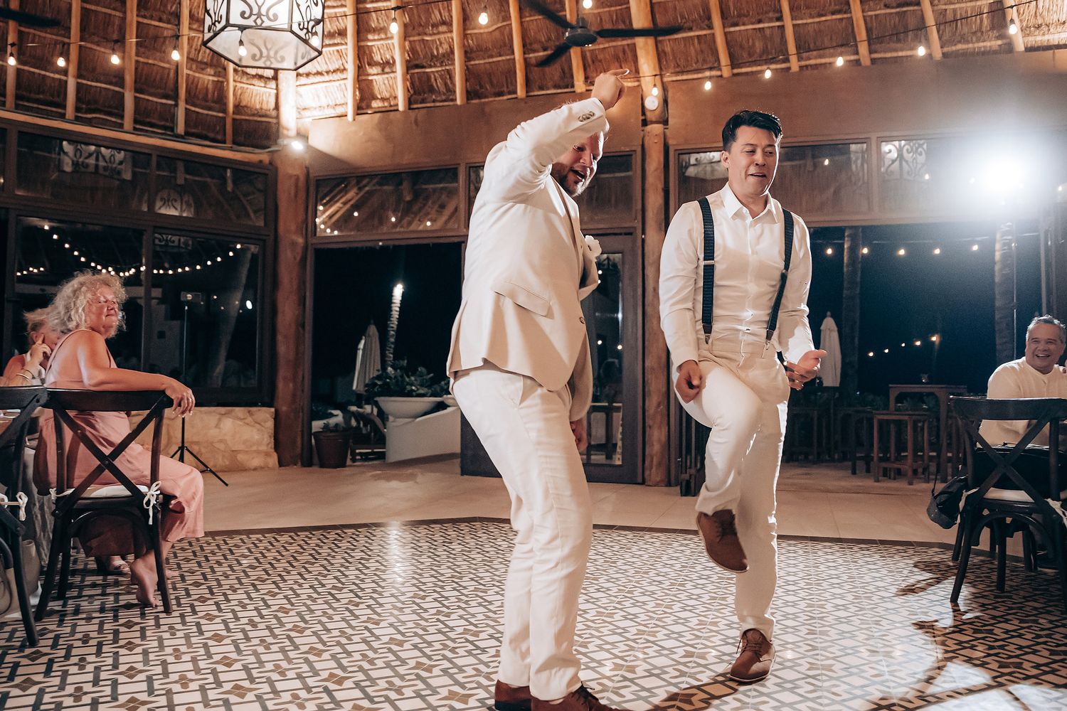 First dance celebration in a rustic barn venue with twinkling lights overhead.