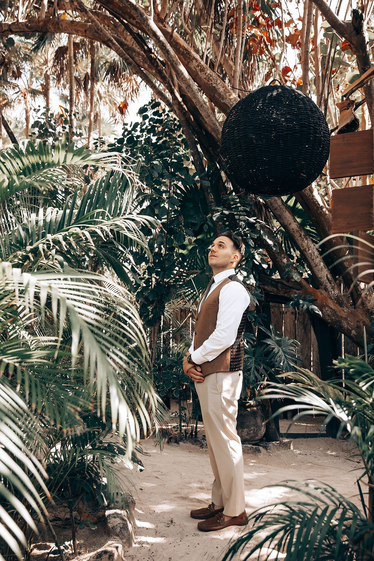A sequence of romantic poses in a lush tropical garden setting with palm fronds.