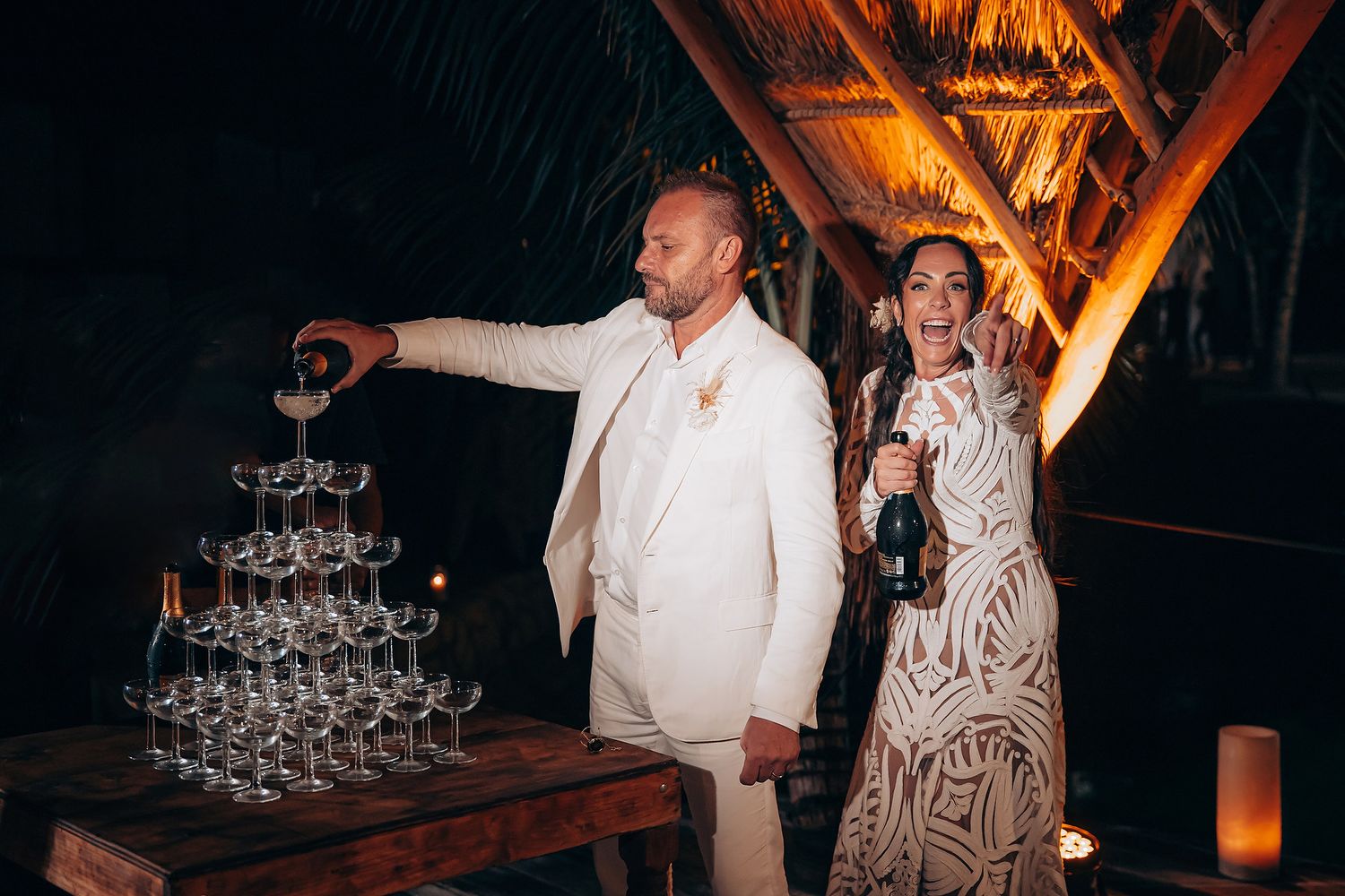 Champagne tower setup at an elegant outdoor evening event with ambient lighting.