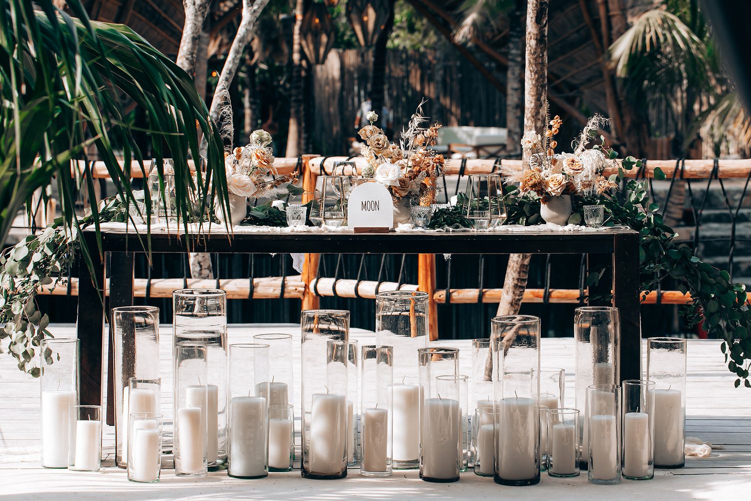 White candles line a rustic outdoor wedding venue path creating a romantic ambiance.