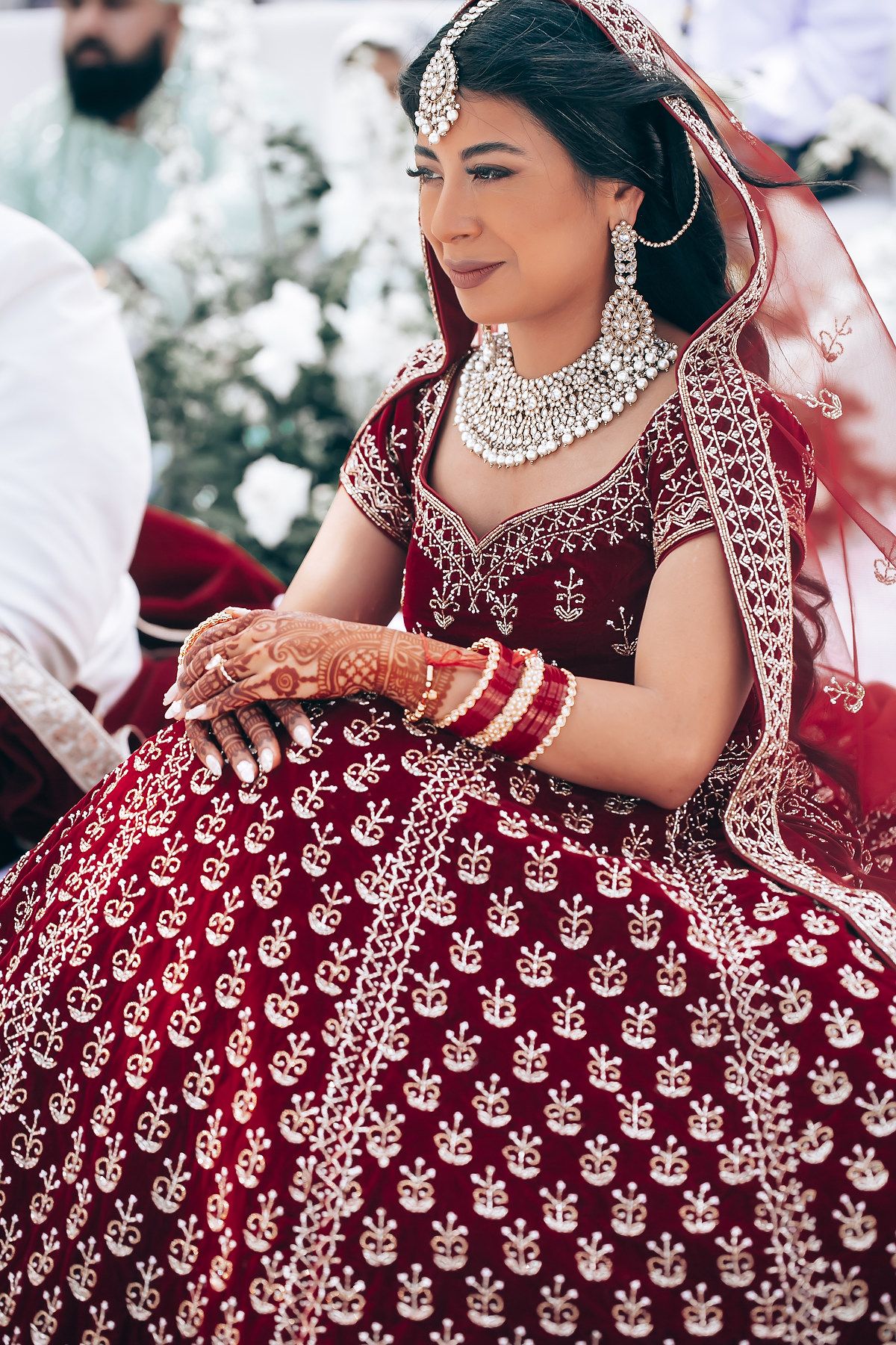 Detailed view of an ornate red and gold embroidered Indian wedding lehenga.