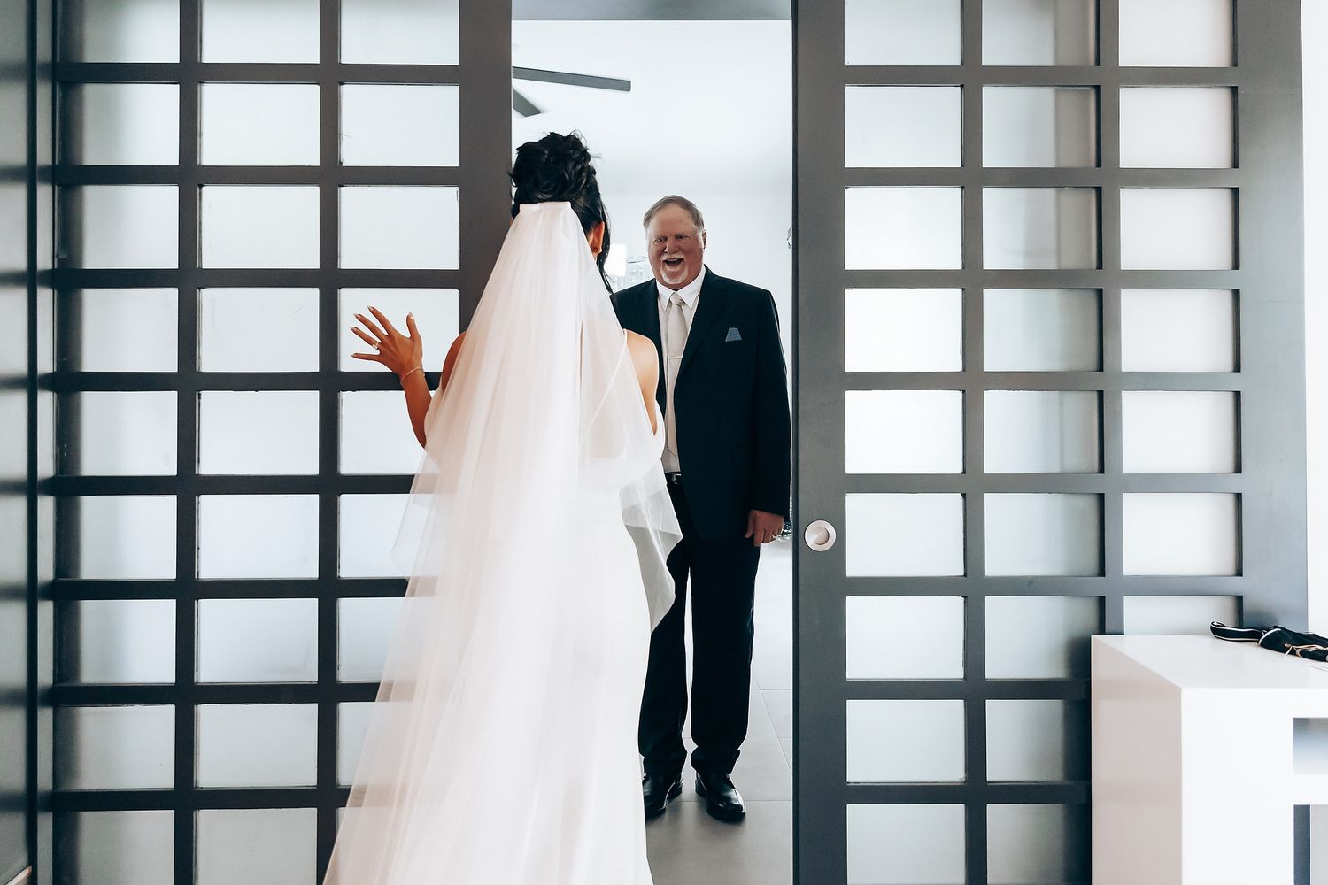Modern wedding venue interior with geometric window panels and bright natural light.